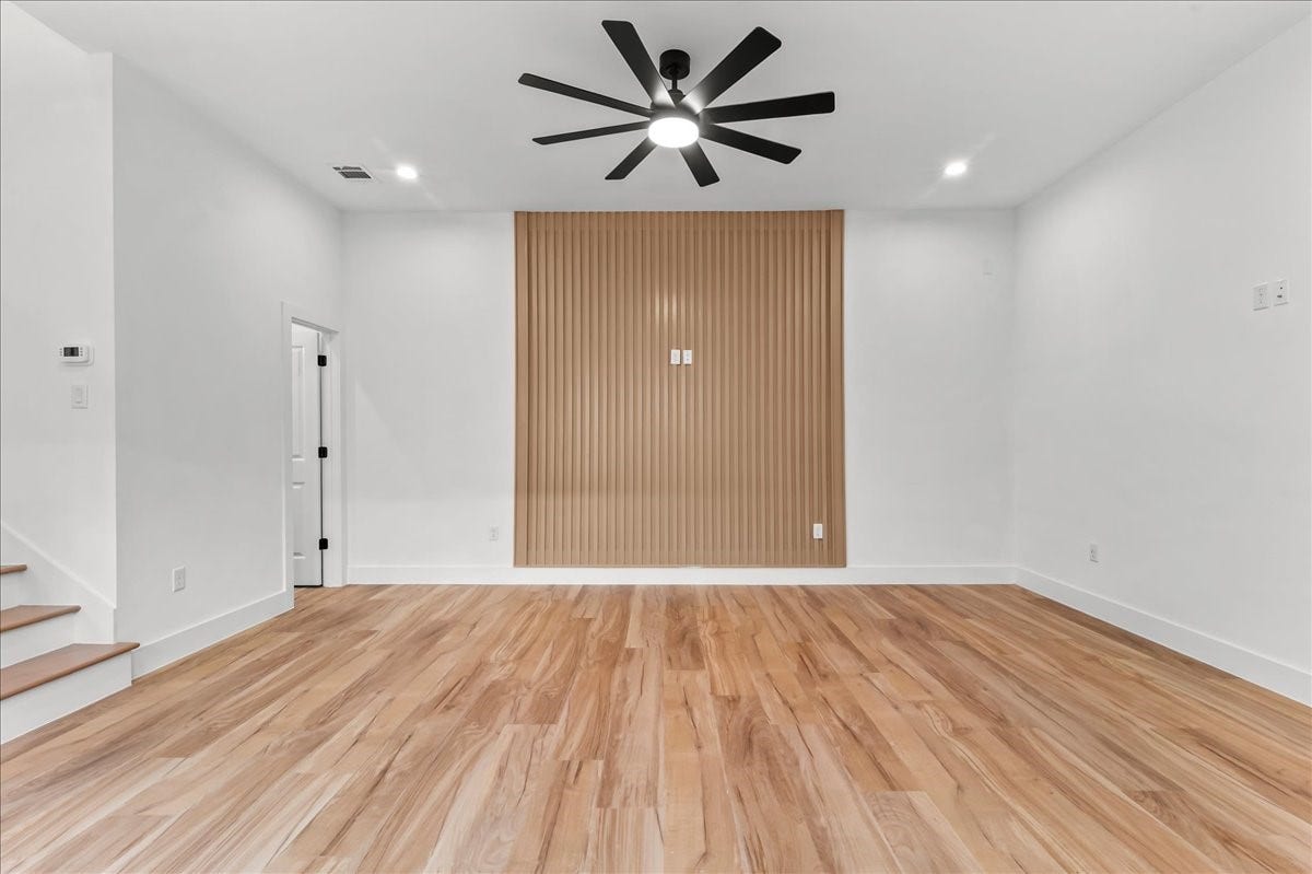 8323 Observatory Street, #A/B, Houston, TX 77088 Unit B - Upon entry, youll be welcomed by a spacious living room featuring a stunning accent wall that beautifully complements the flooring, creating a warm and cohesive design. Recessed lighting and a modern ceiling fan enhance the space, providing both style and comfort while filling the room with a bright, inviting atmosphere.Accent Wall design may vary. Pictures are from a previous build.