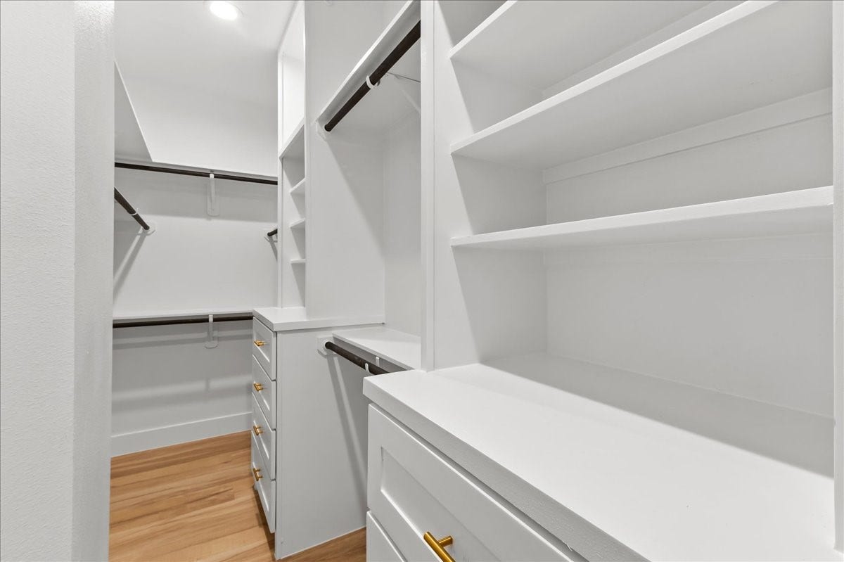 8323 Observatory Street, #A/B, Houston, TX 77088 Unit A - The spacious primary closet is thoughtfully designed with custom built-in shelving and drawer chests, providing ample storage and organization while adding a luxurious, boutique-style feel to your daily routine. Custom closet design may vary. Pictures are from a previous build.
