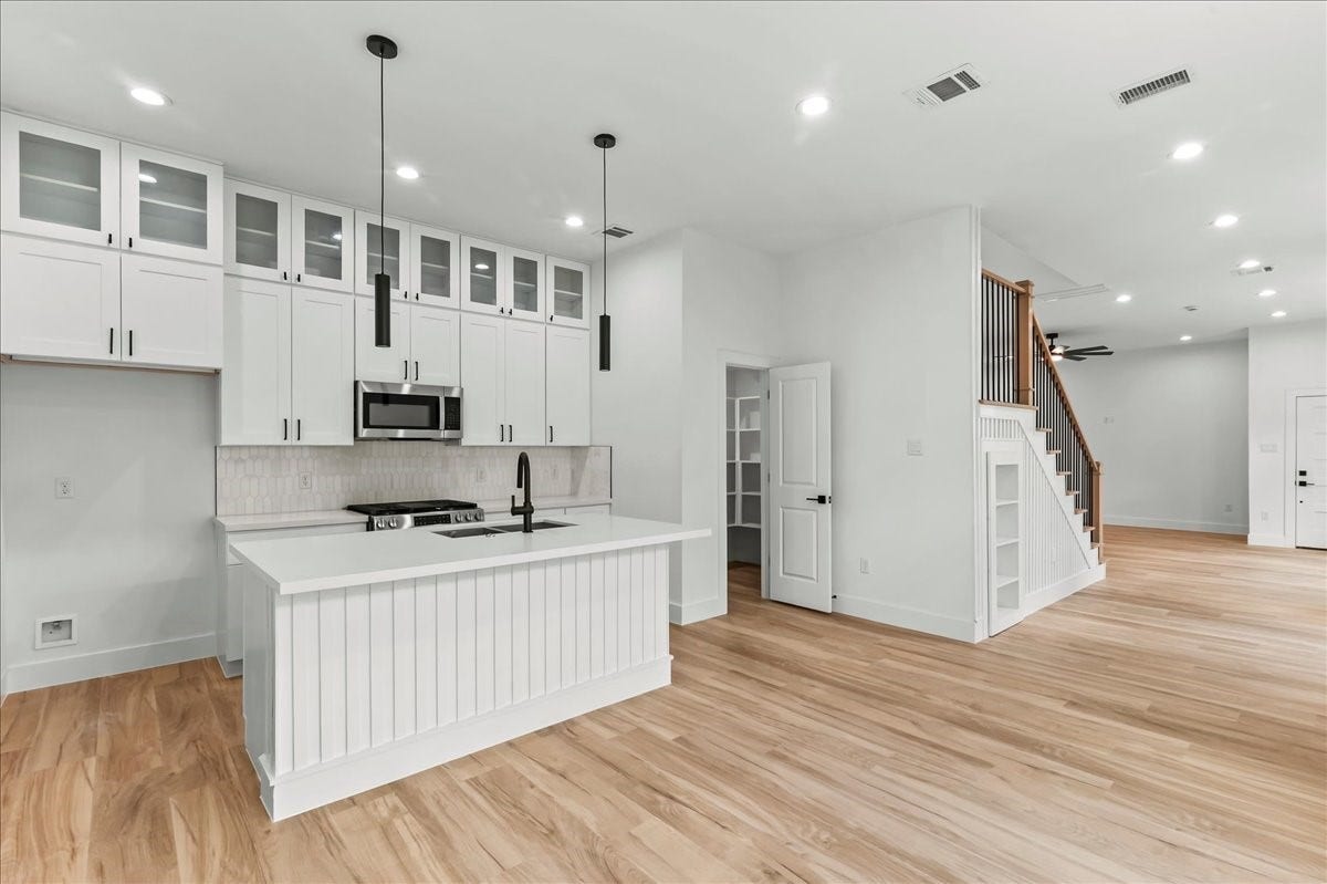 8323 Observatory Street, #A/B, Houston, TX 77088 Unit B - A chefs paradise, this modern kitchen features double stacked cabinetry, stainless steel appliances, and luxurious quartz countertops. Ideal for cooking and entertaining. Design may vary. Pictures are from a previous build.
