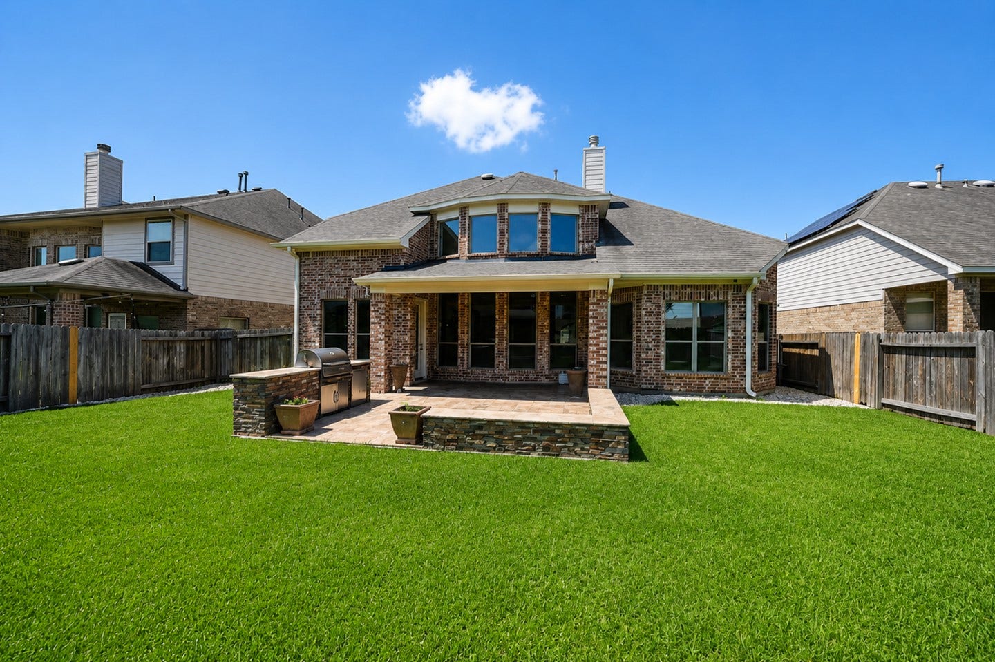 6323 Orange Blossom Lane, Rosenberg, TX 77471 Charming brick home with a spacious, well-maintained backyard. Features a covered patio and built-in grill area, perfect for outdoor entertaining.