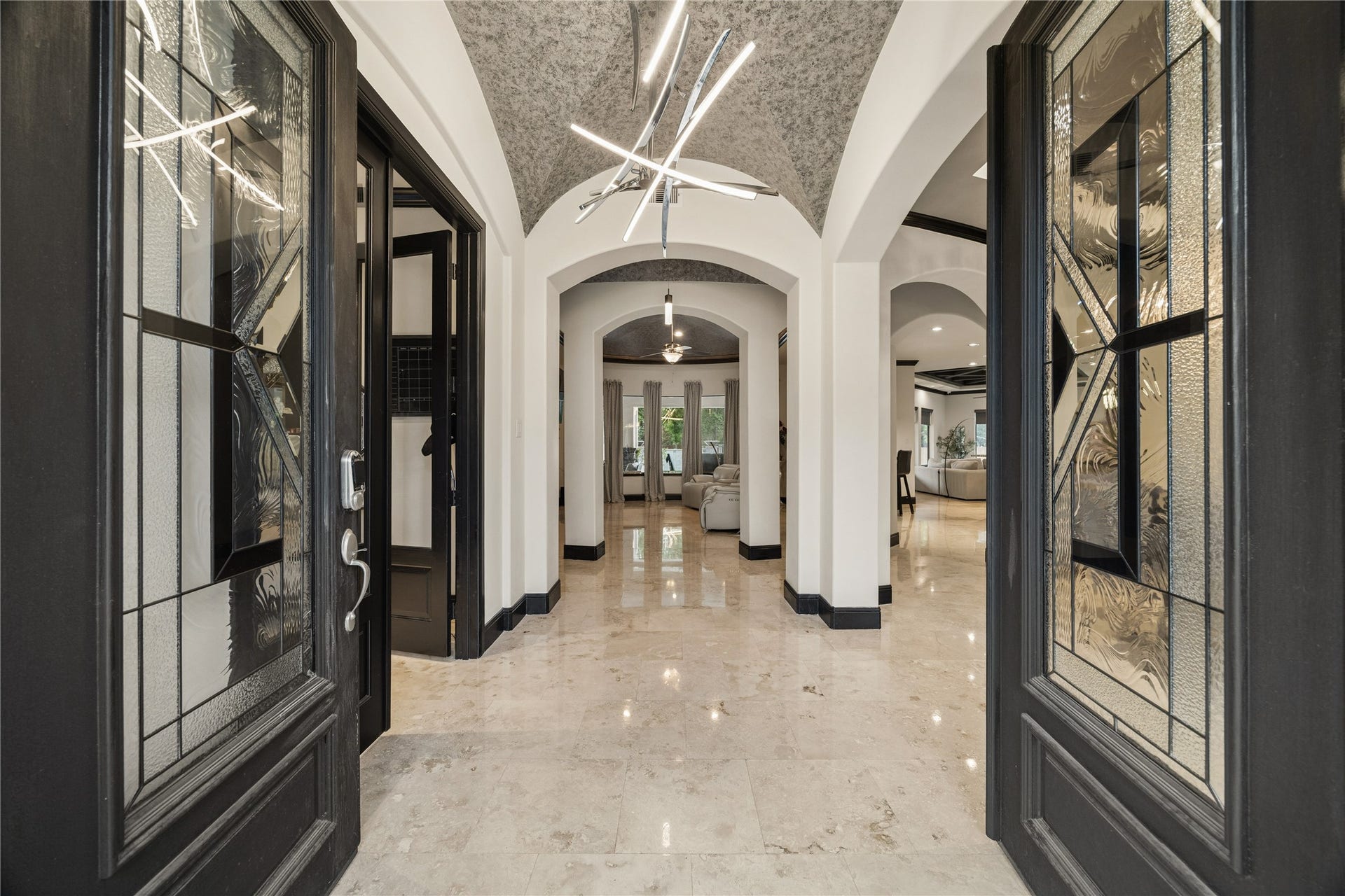27303 E Benders Landing Boulevard, Spring, TX 77386 Double door entry welcomes you into an elegant foyer with a beautiful modern light fixture, barrel vaulted ceiling with decorative finishes, and travertine flooring throughout the home.