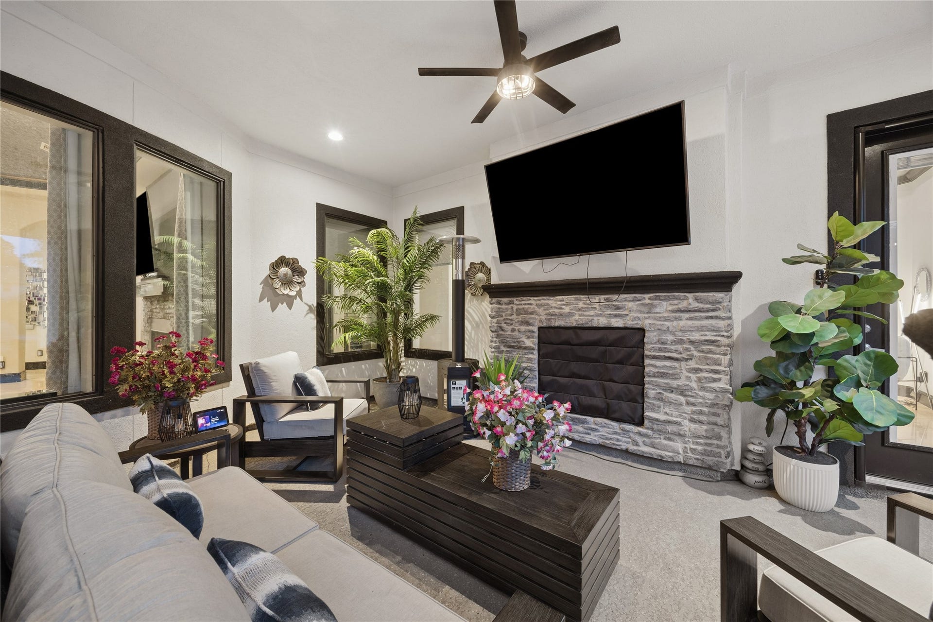 27303 E Benders Landing Boulevard, Spring, TX 77386 Relax and unwind in this inviting outdoor lounge area featuring a stone fireplace, mounted entertainment space, ceiling fan with lighting. Great setting to gather with family and friends while enjoying the ambiance of this resort-style outdoor retreat.