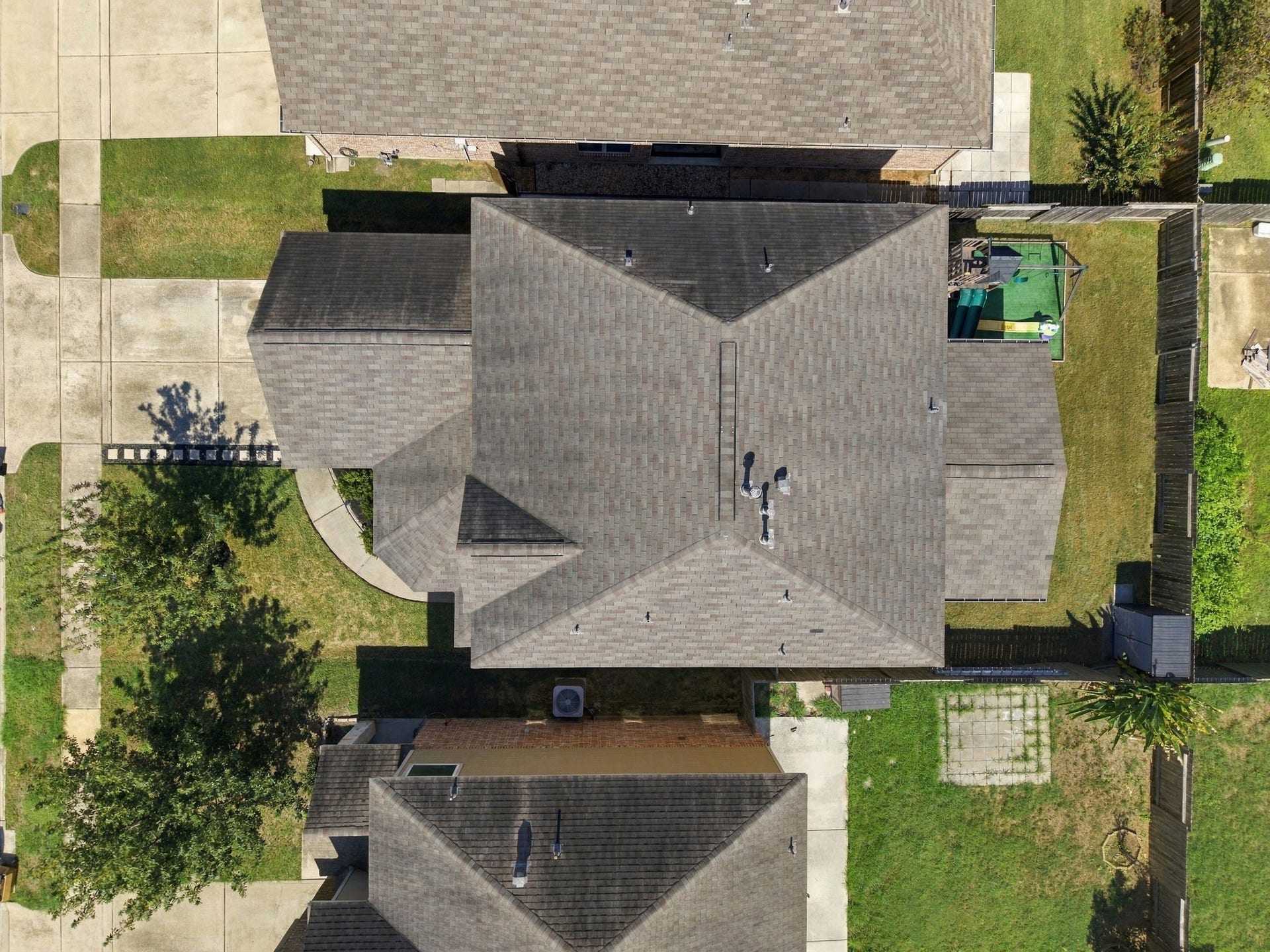 Aerial View: Overhead aerial showcases the home's footprint, roofline, fenced backyard and substantial covered outdoor living area.