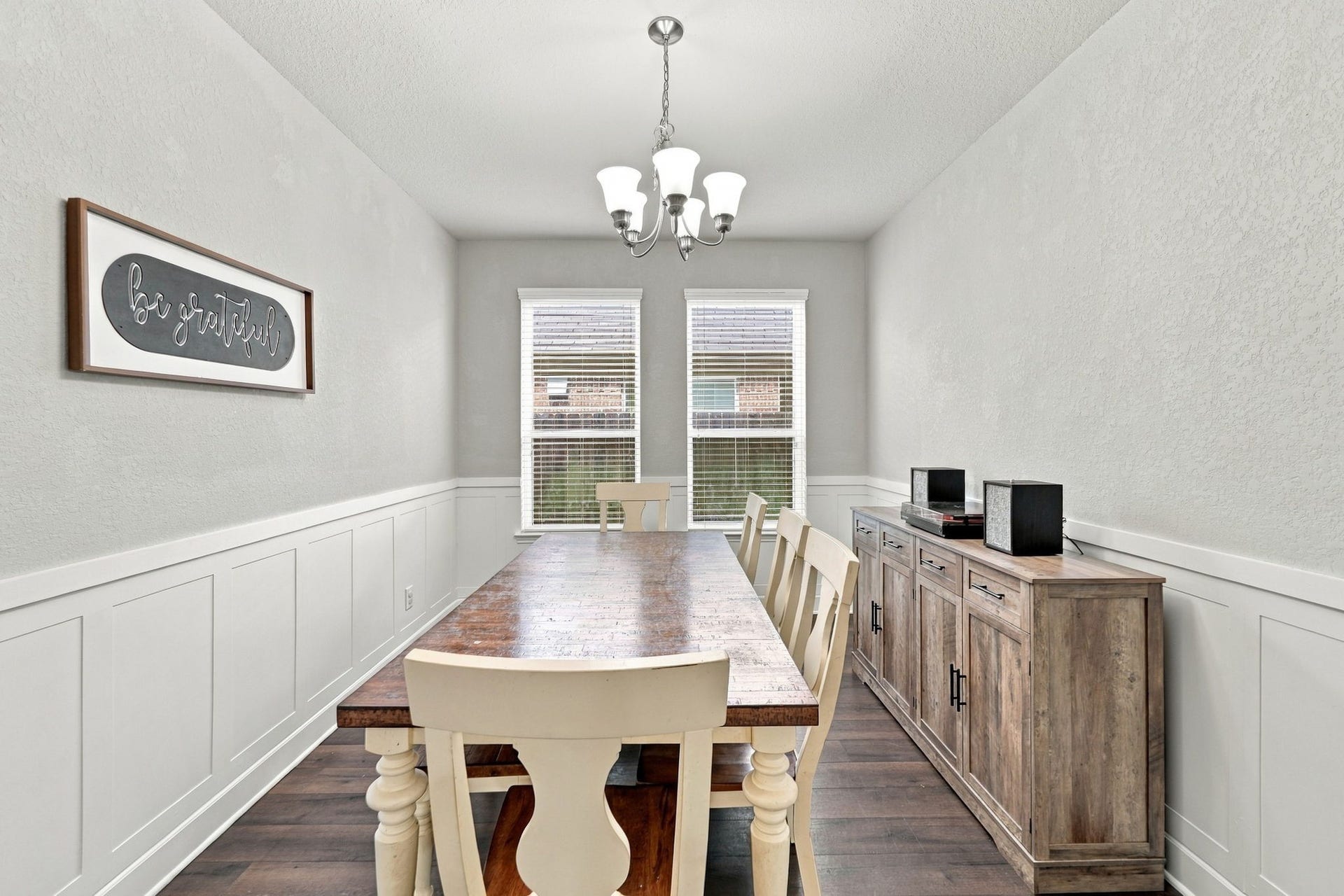 Formal Dining: Dedicated dining room features decorative wall detailing, twin windows and ample space for a full-size dining table.