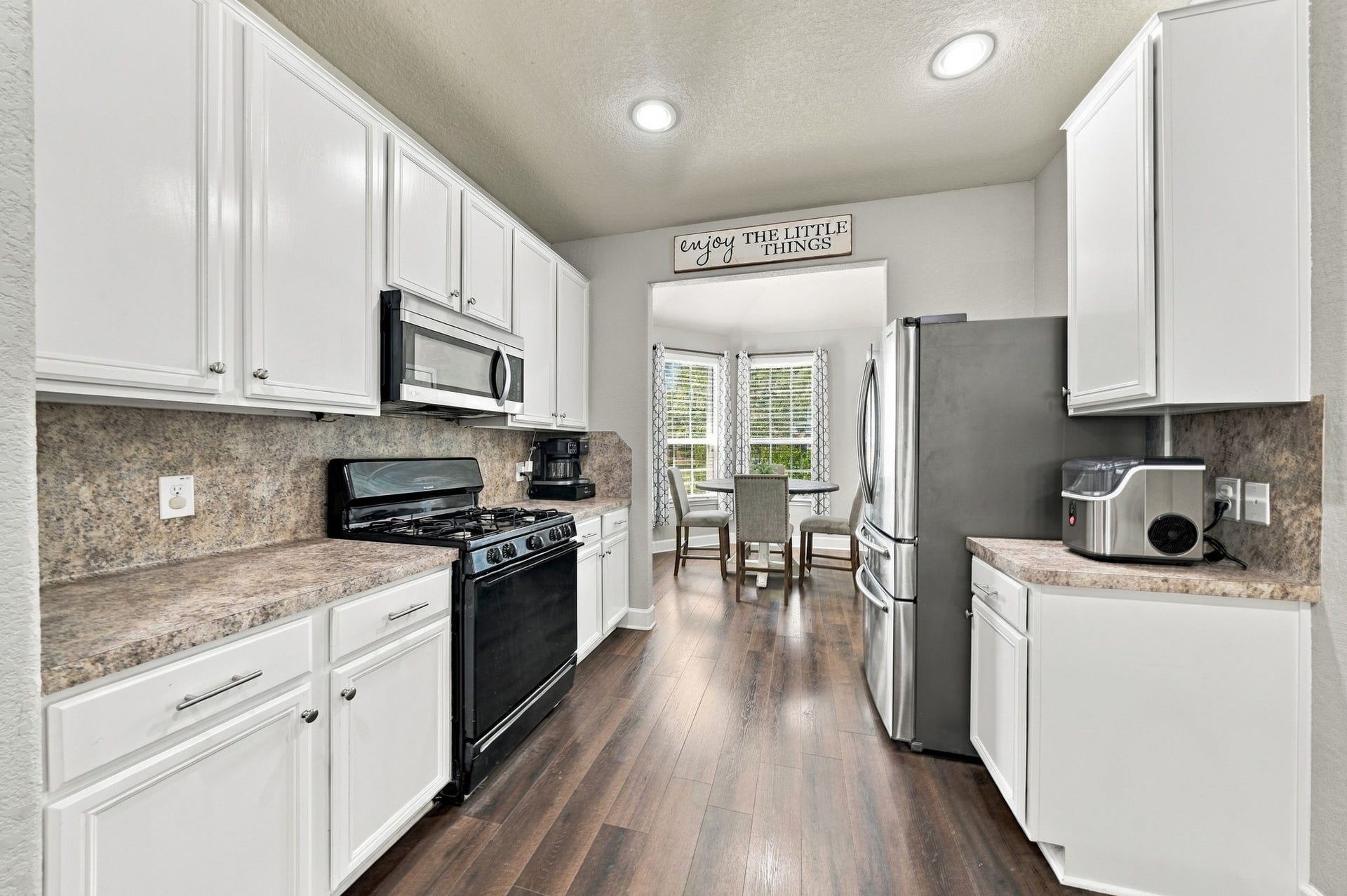Kitchen: Bright kitchen features crisp white cabinetry, generous counter space and a natural connection to the adjacent breakfast area.