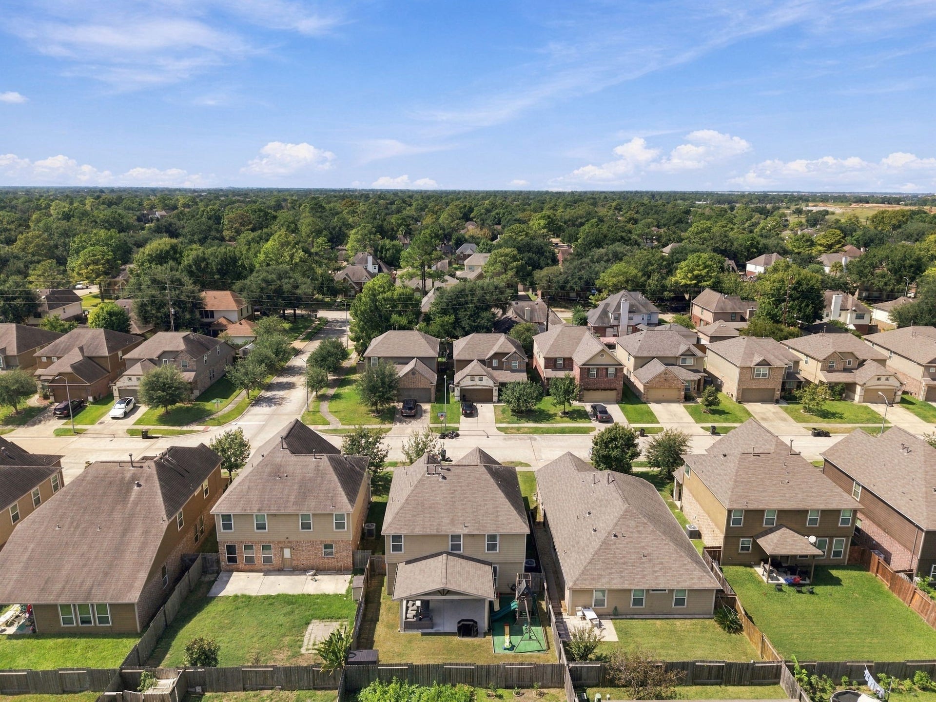 Aerial Community View: Expansive aerial view showcasing the home and surrounding residential community with established streets and mature greenery.