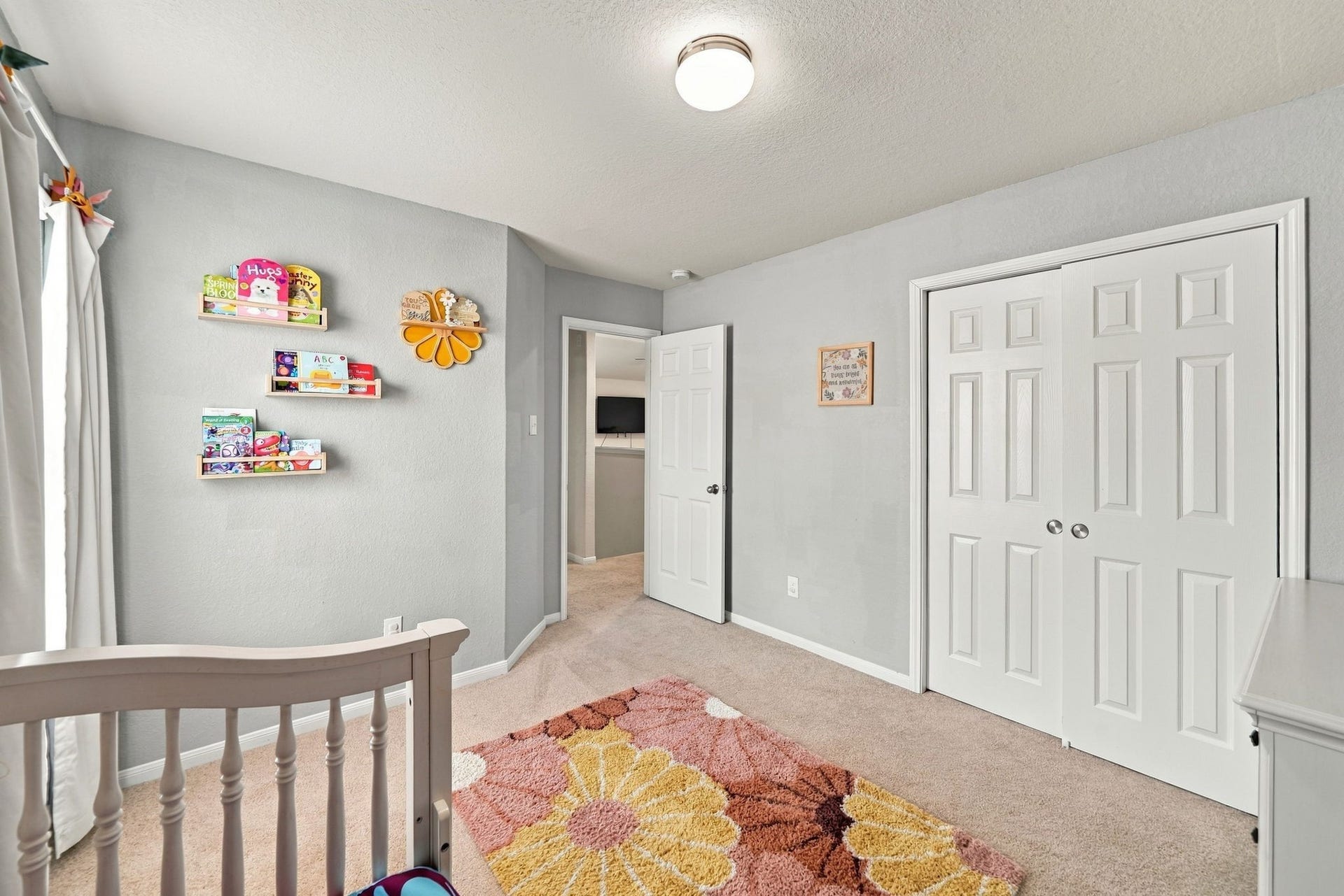 Secondary Bedroom: Bright secondary bedroom with neutral tones, carpet flooring, generous closet space, and natural light.
