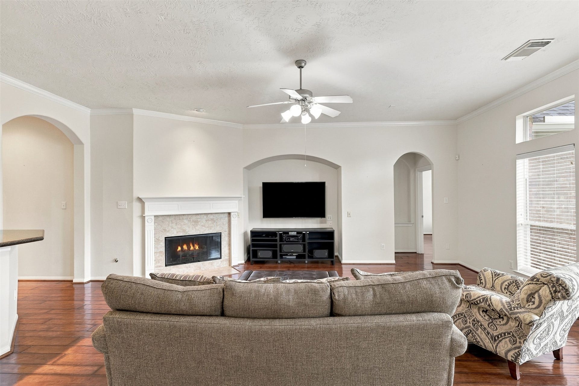 6522 Pine Reserve Drive, Spring, TX 77389 Spacious living room with a cozy fireplace, elegant archways, and abundant natural light.