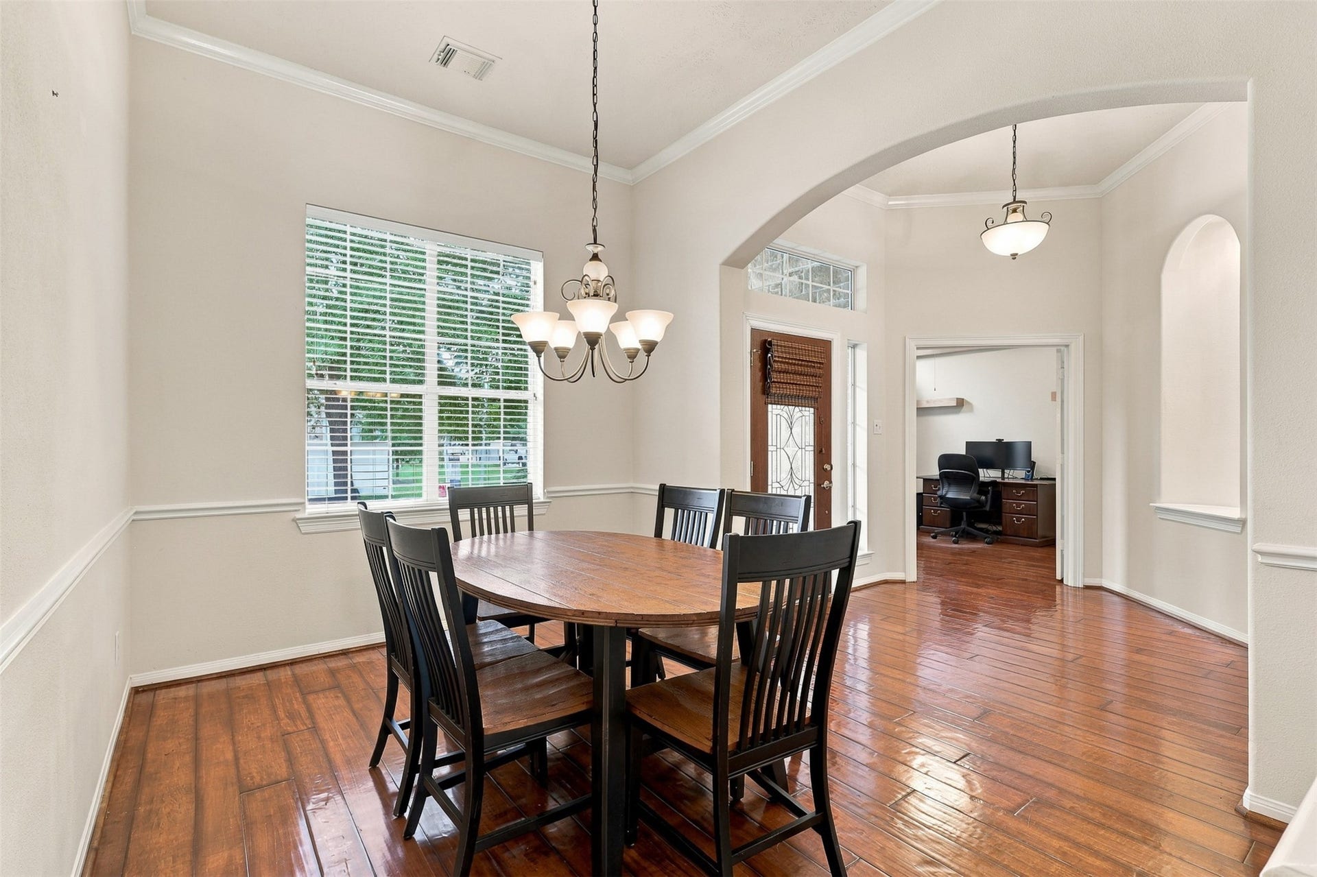 6522 Pine Reserve Drive, Spring, TX 77389 Elegant dining room with abundant natural light, featuring a stylish chandelier and polished hardwood floors.