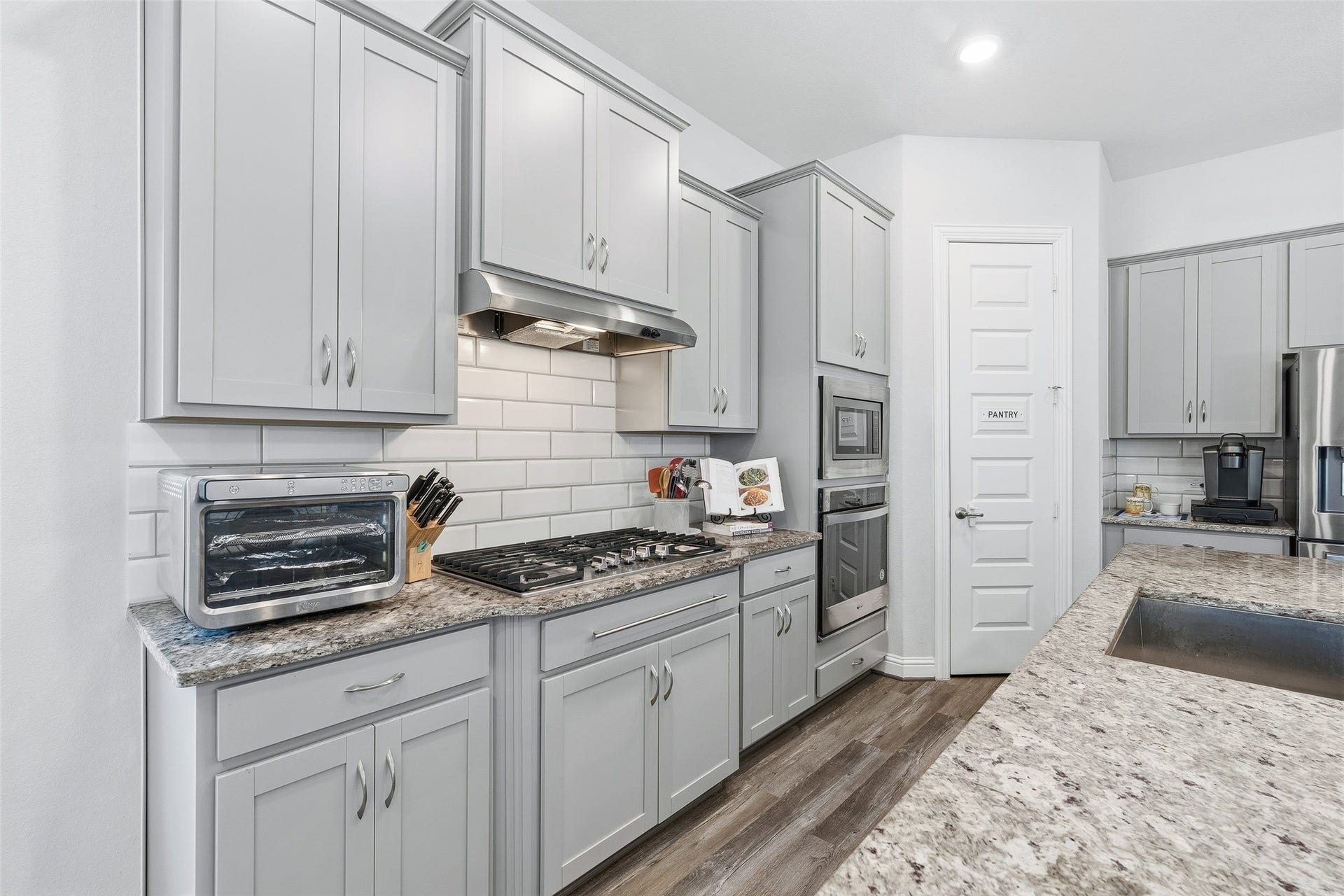 Move freely in this spacious chefs kitchen, featuring stainless steel appliances and a five-burner stove for effortless meal preparation. Expansive granite countertops provide plenty of room for prepping and serving, while the generous breakfast bar offers additional seating for casual dining and gathering.