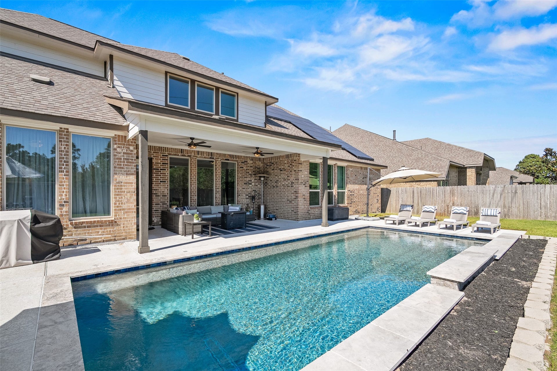 Back to the pool! A large covered patio with remote controlled fans accommodates more than just large furniture.  Pool specs: 14 'x 32' Gunite pool 3.5' deep x 5.5' deep and there are no neighbors or buildings behind the lot.
