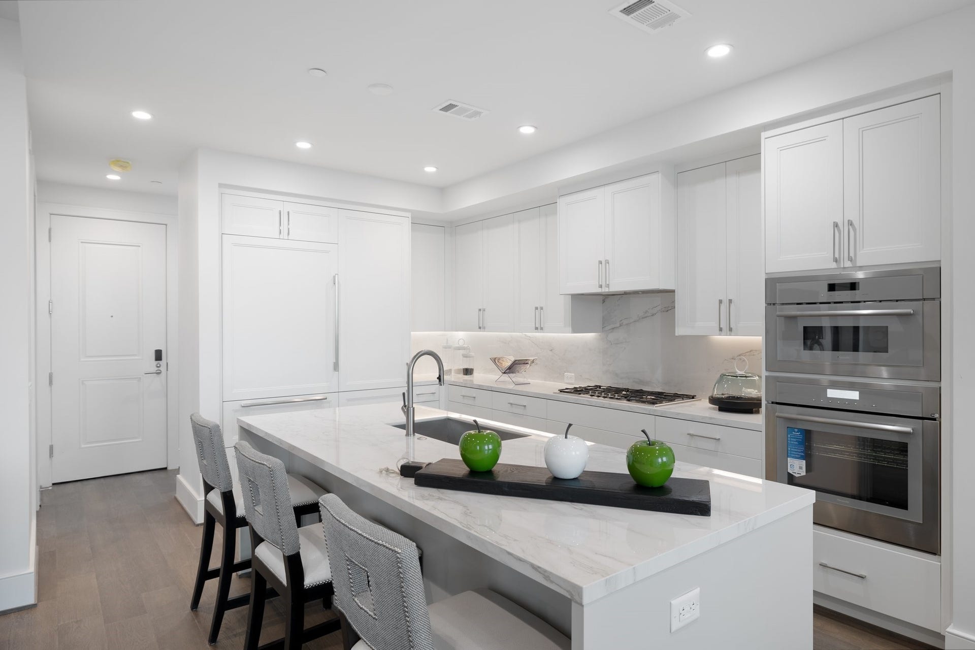 5656 San Felipe Street, #1403, Houston, TX 77056 Featuring sleek white cabinetry, elegant quartz countertops, and a marble backsplash. Photos are of a similar unit with the same floor plan