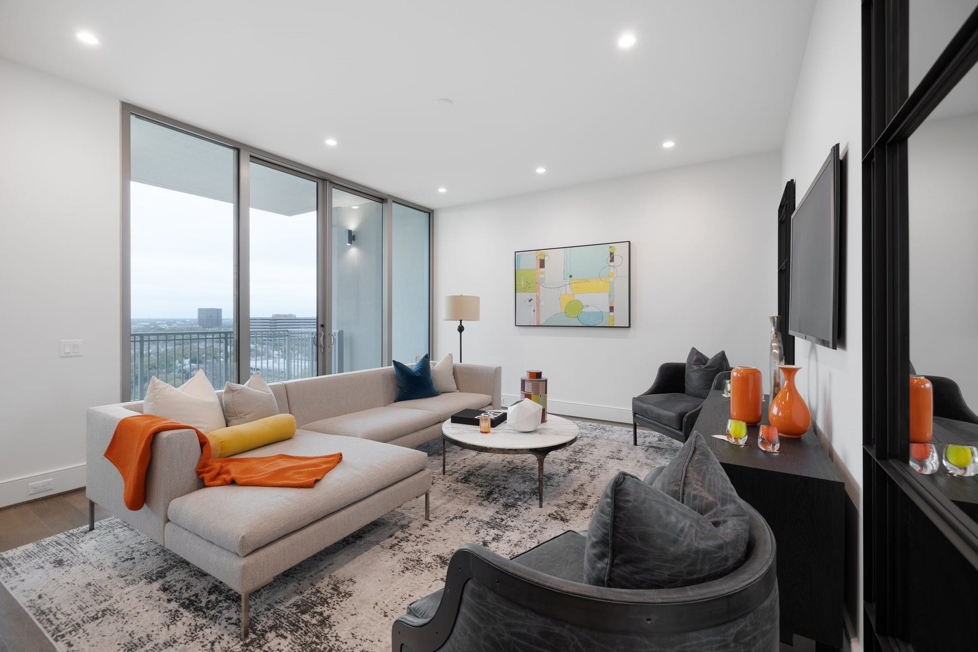 5656 San Felipe Street, #1403, Houston, TX 77056 Open living space with expansive floor-to-ceiling windows, providing abundant natural light and sweeping views of the city. The spacious layout features clean architectural lines, recessed lighting, and direct access to a private balcony. Photos are of a similar unit with the same floor plan