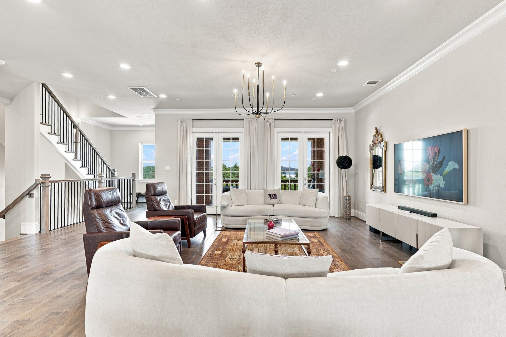 183 Grace Point Drive, Sugar Land, TX 77498 Beautiful Family room with rich wood flooring and designer fixtures. 2 sets of french doors leading to the private balcony overlooking the lake.