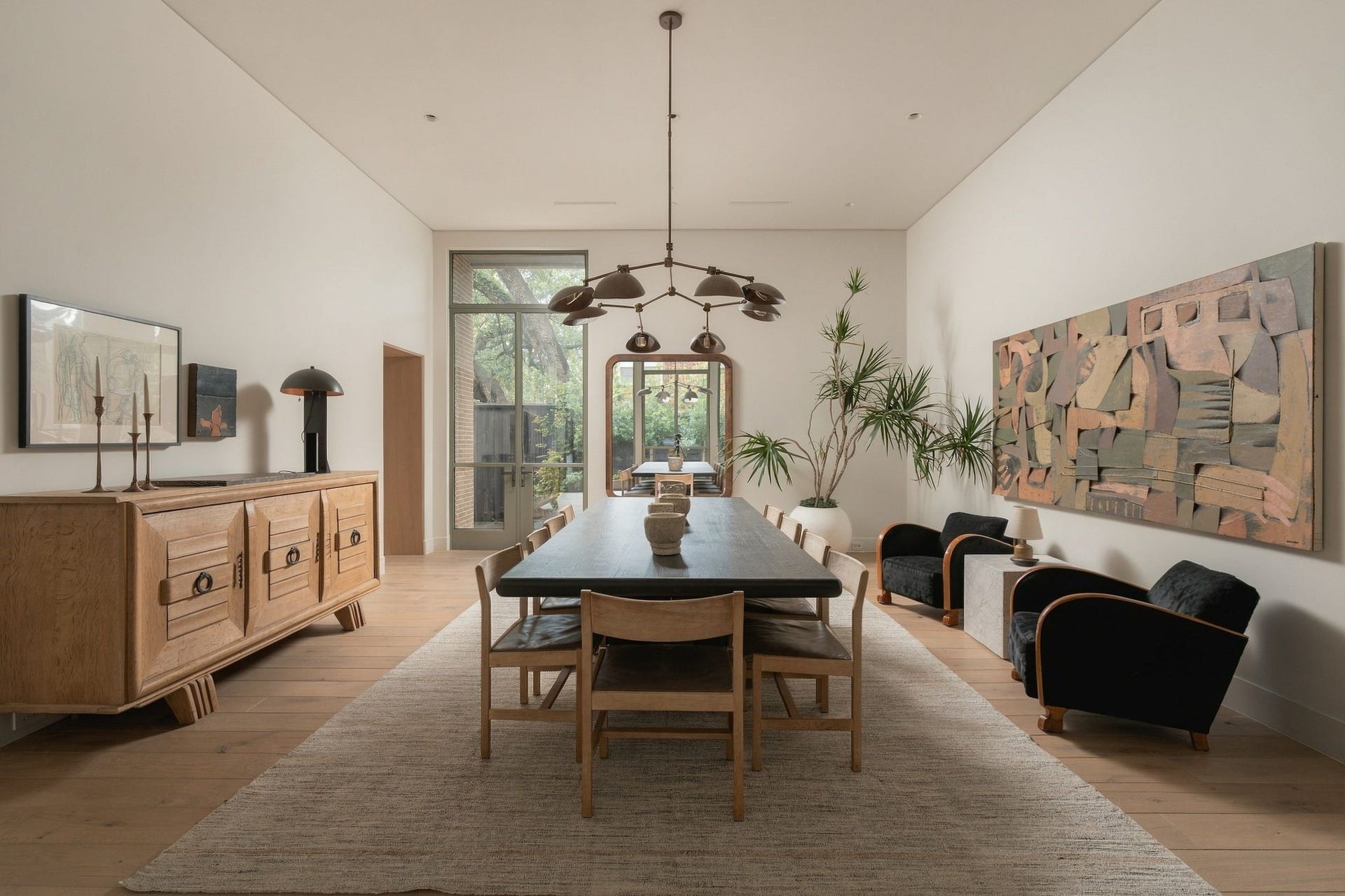 Light-filled formal dining w/ custom steel doors opening to the side yard/summer kitchen. A rift white oak-paneled entry connects directly to the scullery for easy service, thoughtfully positioning the room for both intimate dinners & effortless entertaining.