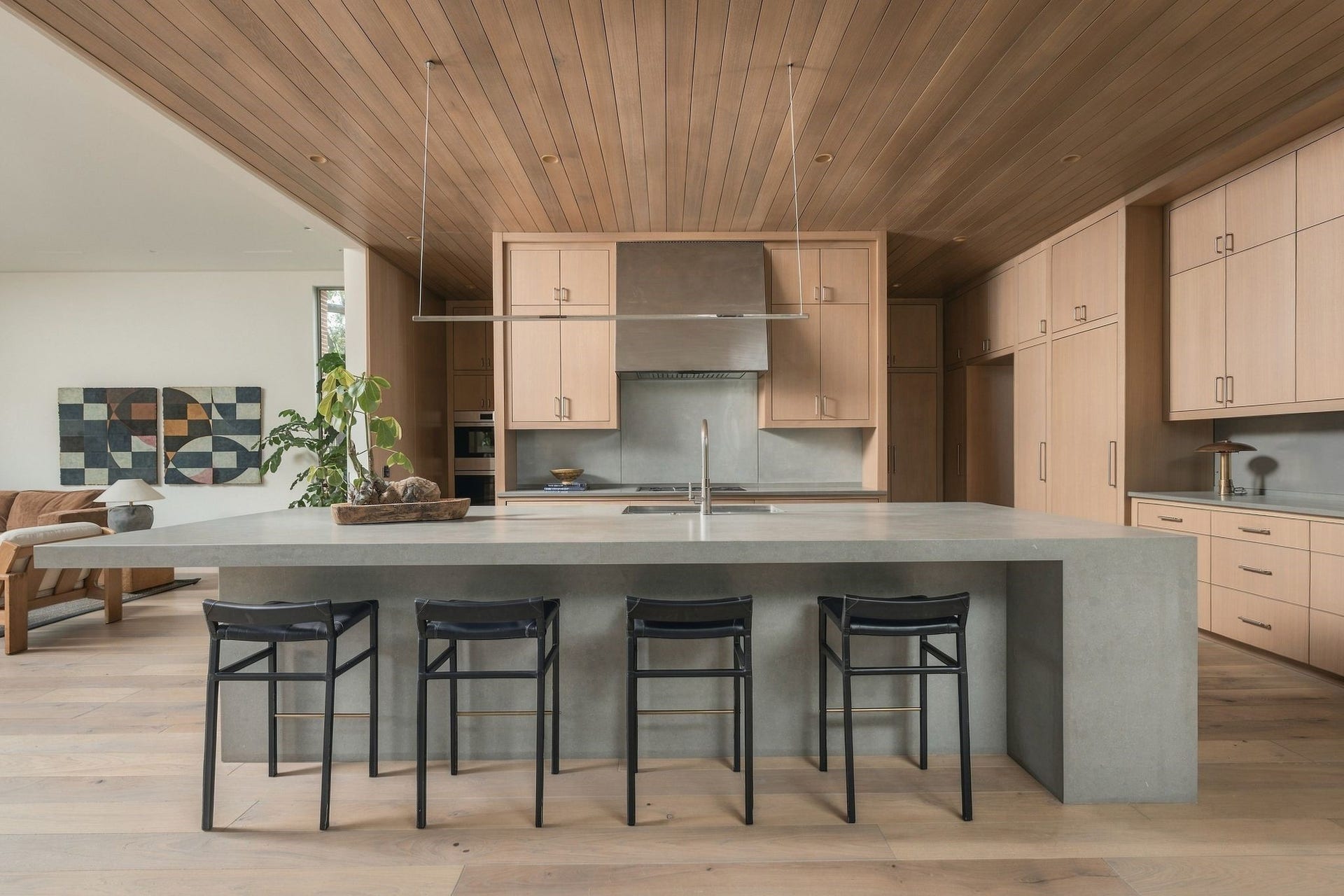 A beautifully composed, fully equipped kitchen where every detail was considered to framenot distract fromthe green space beyond. Custom rift white oak cabinetry, oversized island, white oak-paneled ceiling & custom-finished stainless steel create striking symmetry, grounded by exceptional materials & craftsmanship.