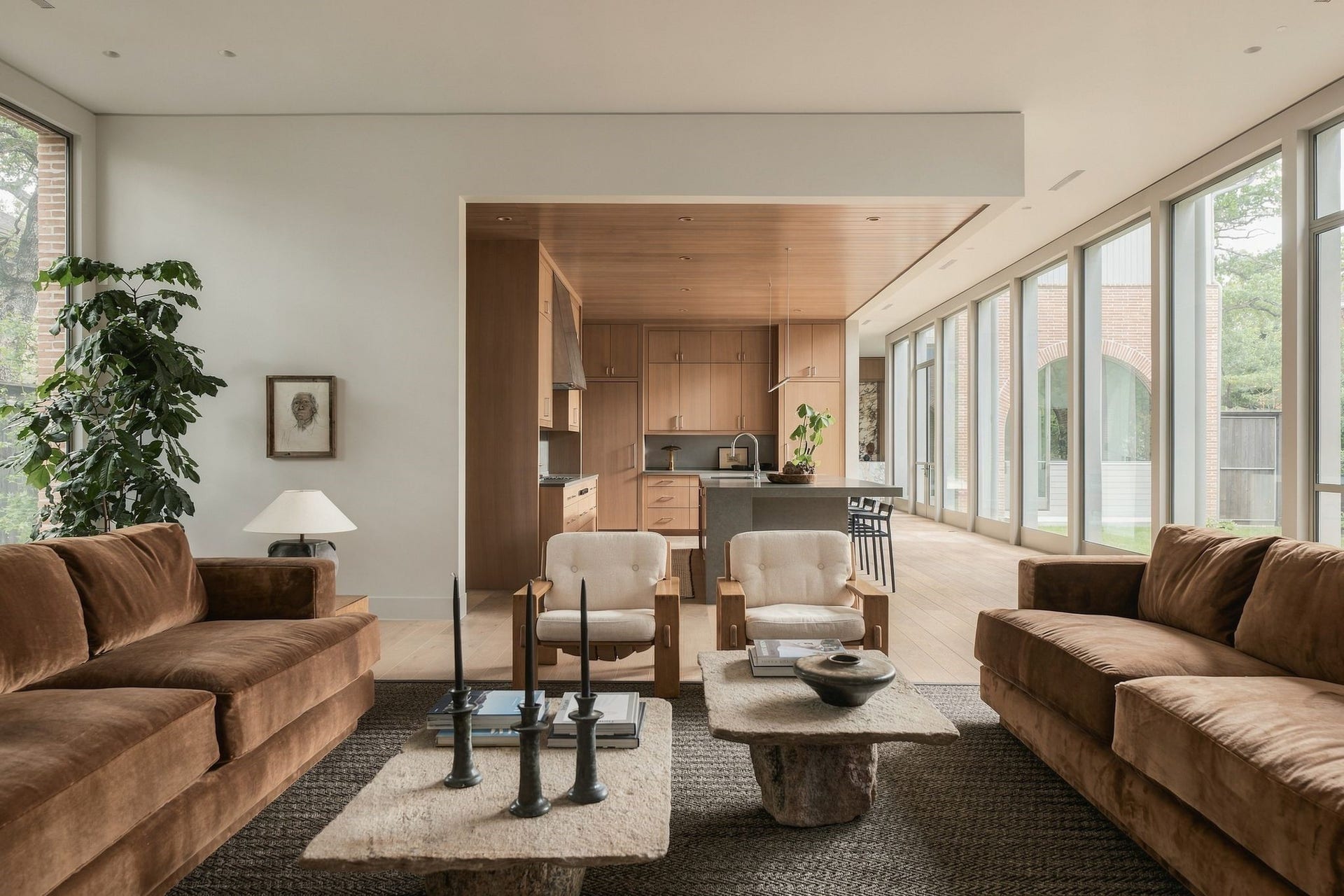 Another perspective captures the effortless flow between the family room & kitchen. A large picture window was intentionally positioned to highlight a mature oak, while the wall of glass opposite brings the backyard into viewevery sight line thoughtfully composed to connect the interiors w/the landscape.