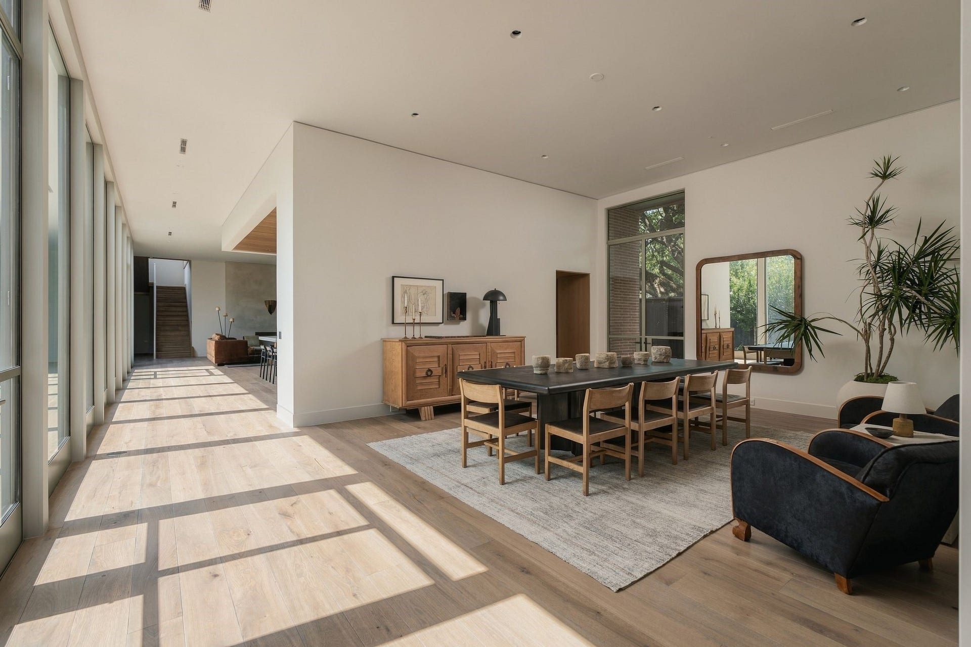 The homes architectural procession on full display. From the entry, disciplined sight lines lead toward the dining room, kitchen & family room, while a gallery of glass runs alongside the private backyard. Rather than relying on traditional hallways, the architecture, natural light & landscape guide you from one space into the next.