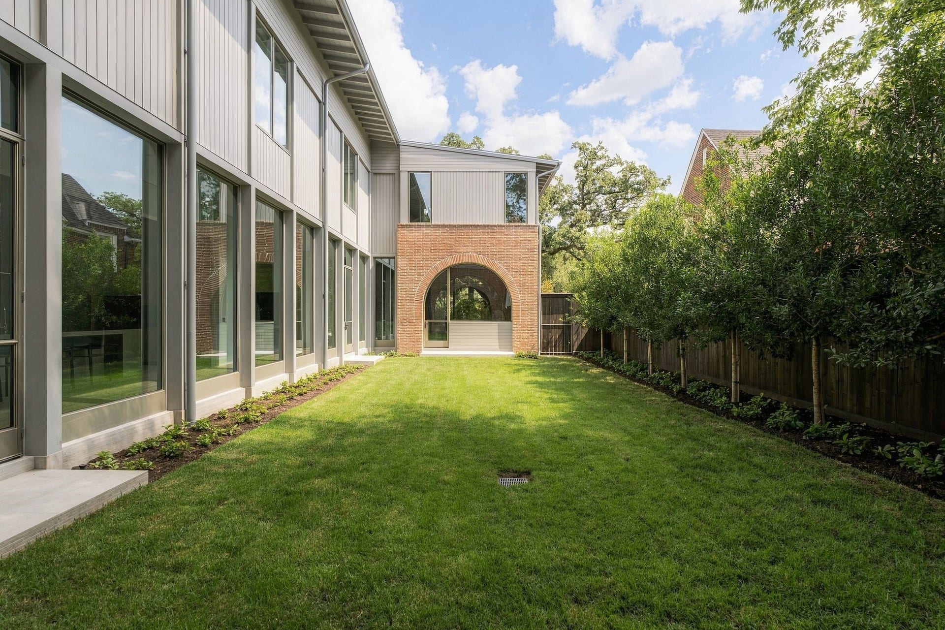 A remarkable architectural sight linethe repeating arches of the covered porch align w/the arched steel windows of the parlour beyond. This symmetry captures the intent behind The Arch House, where disciplined proportion, framed views & the relationship between interior and exterior were considered from every angle.