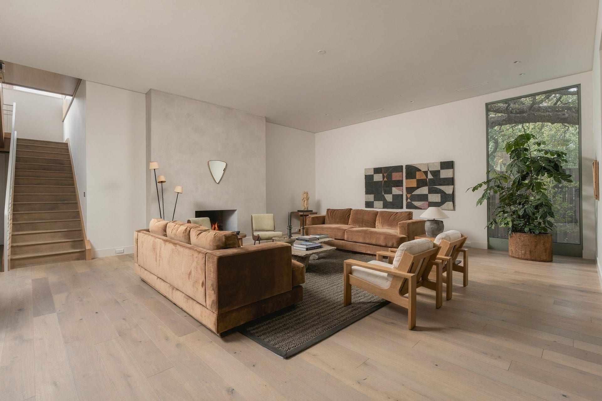 Natural light & thoughtful sight lines define the family room. The diamond-plaster fireplace & sculptural staircase create architectural focal points, while expansive windows frame the surrounding mature trees, allowing the landscape to become part of the interior experience.