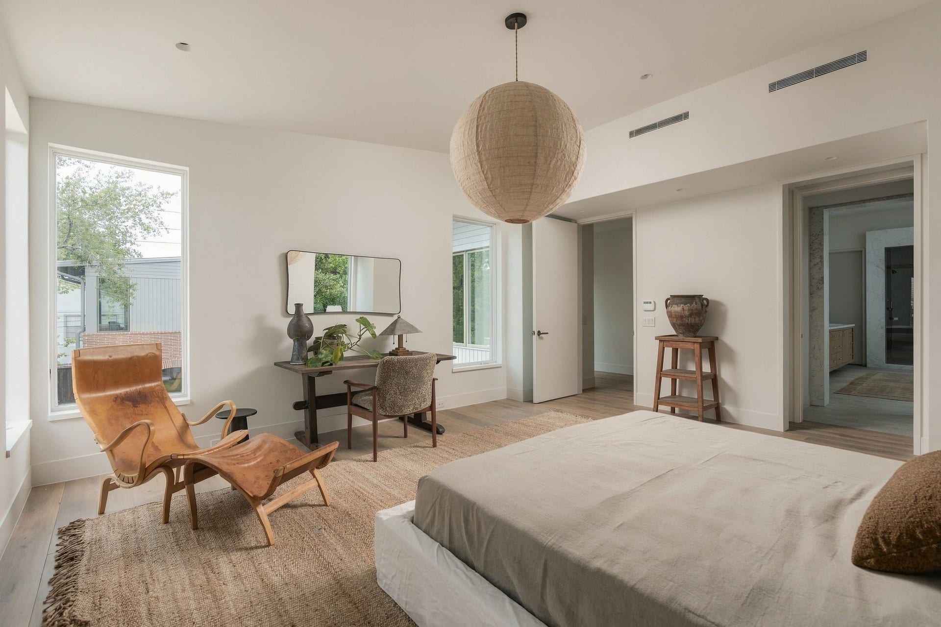 Another perspective of the peaceful primary retreat highlights its scale, vaulted ceiling & thoughtful connection to the adjoining bath. Treetop views bring the outdoors in, creating a private sanctuary tucked away on the second floor.