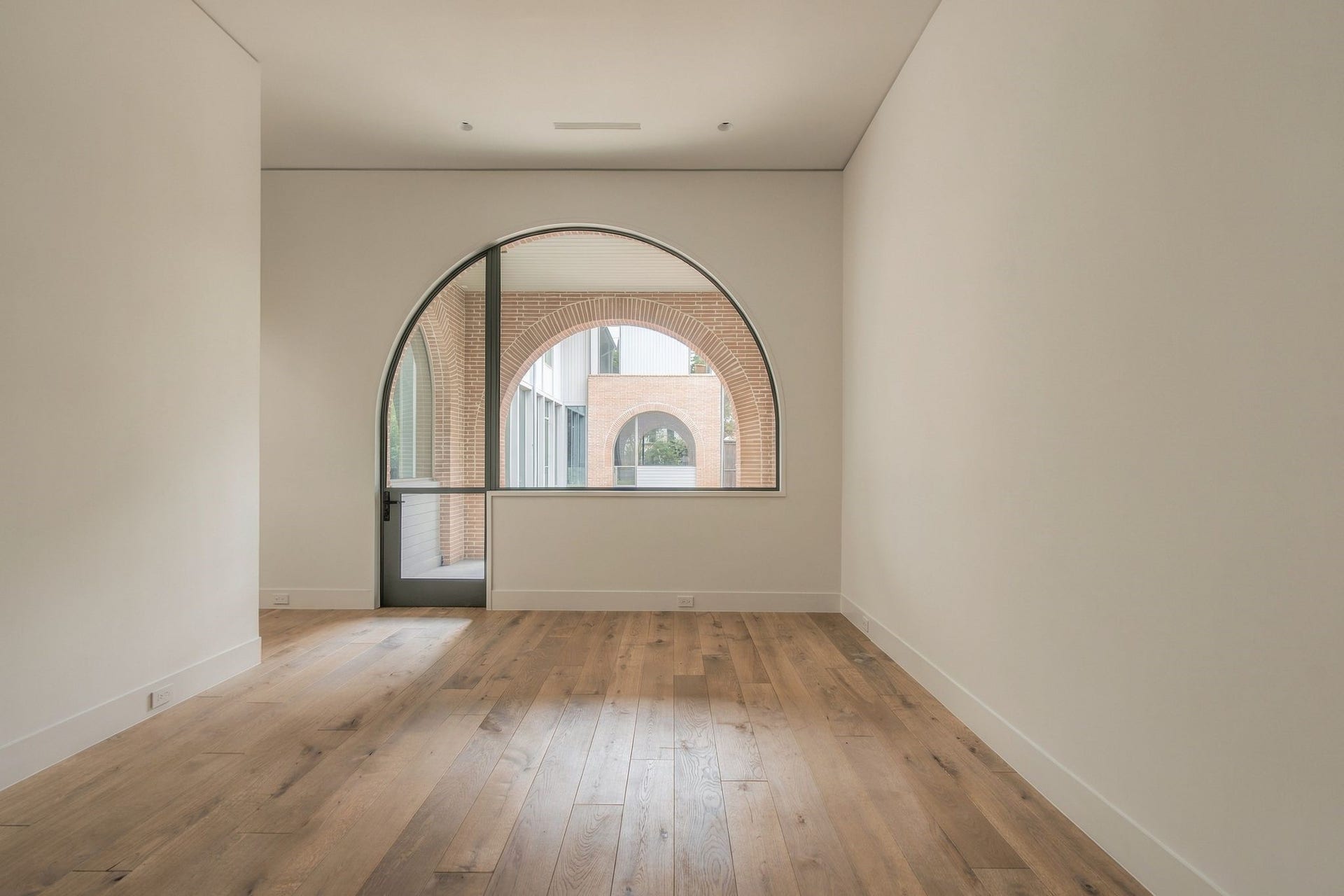 Versatile first-floor study/5th bedroom offers a full en suite bath & beautiful views across the backyard toward the parlour. Arched windows echo the architecture opposite, while a custom steel door opens directly to the covered porch. Ideal as a private guest suite, office, den or playroom.