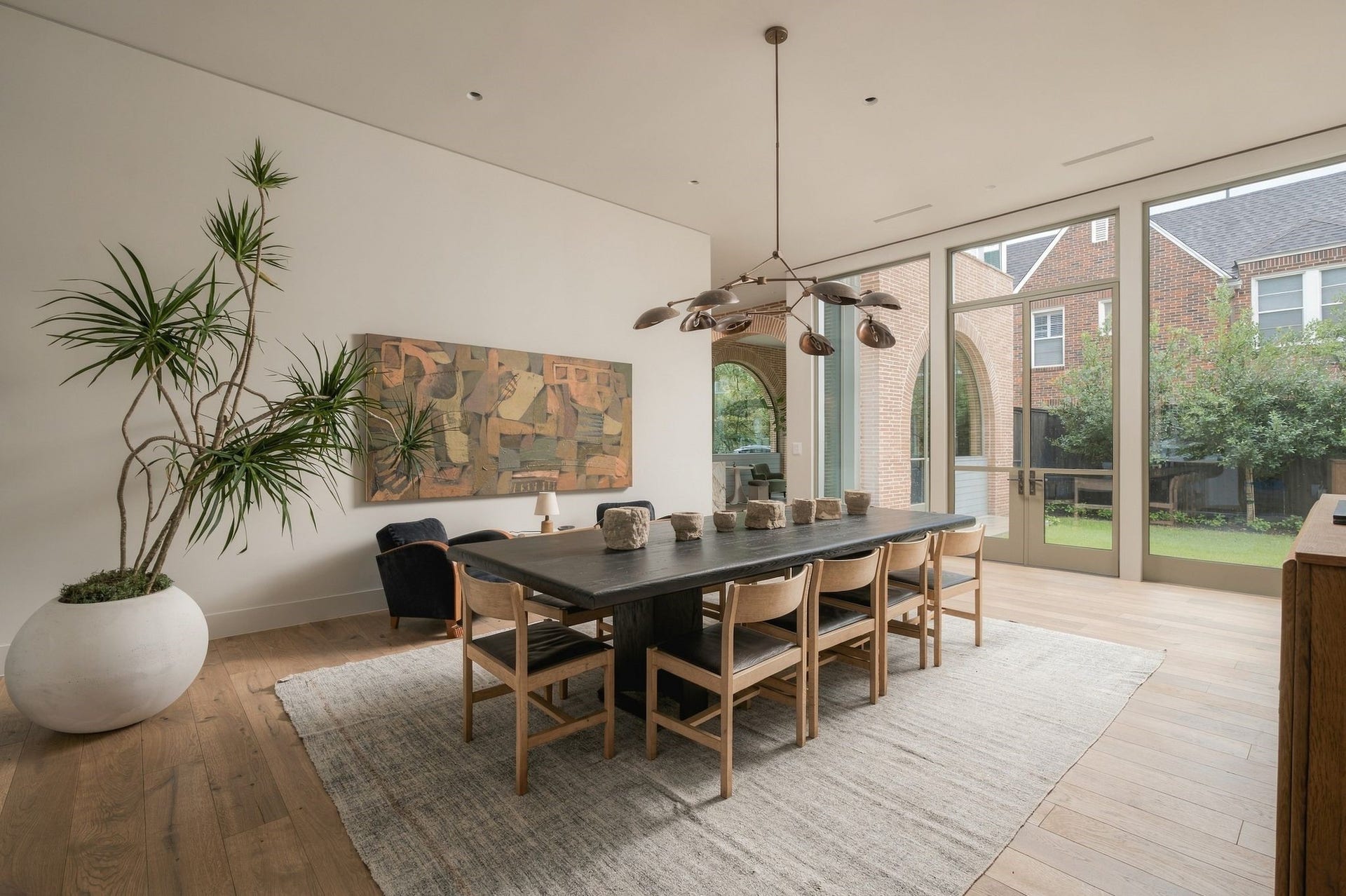 Another perspective highlights the dining rooms connection to the rest of the home. Custom steel doors open to the backyard while the sight line extends back toward the arched parlour, continuing the rhythm of indoor & outdoor spaces that defines The Arch House.