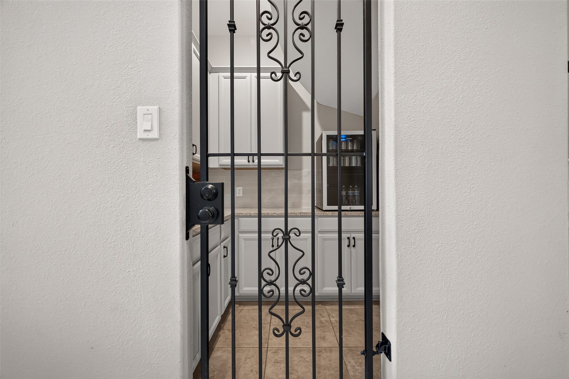 Off the living is the wine room with iron gate.