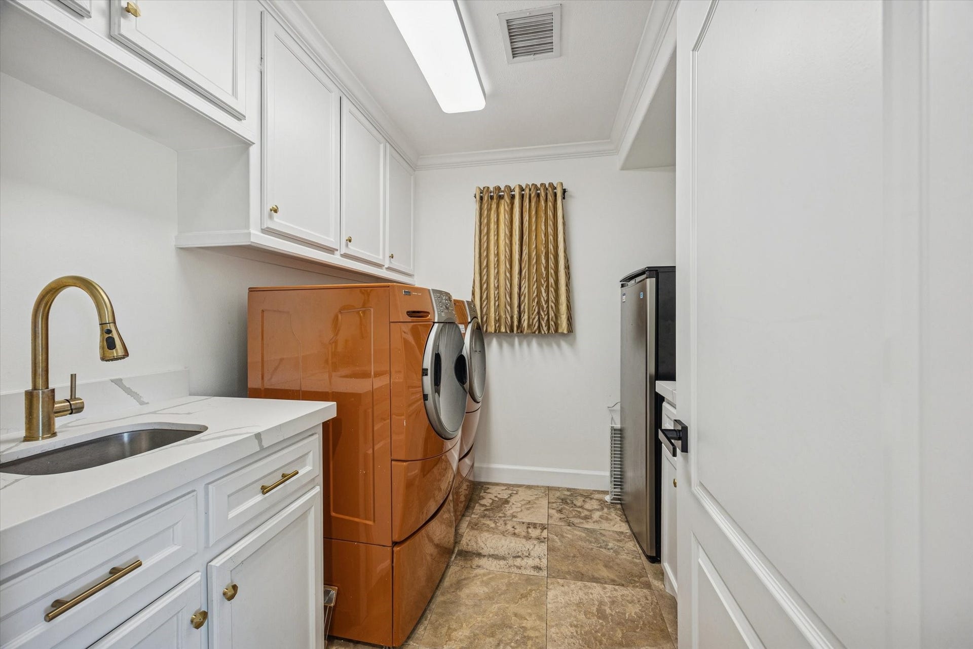 61 Open Sands Court, Sugar Land, TX 77479 Spacious laundry room with ample cabinetry for storage, a sink with a modern faucet. There is room for another refrigerator or freezer in this space.