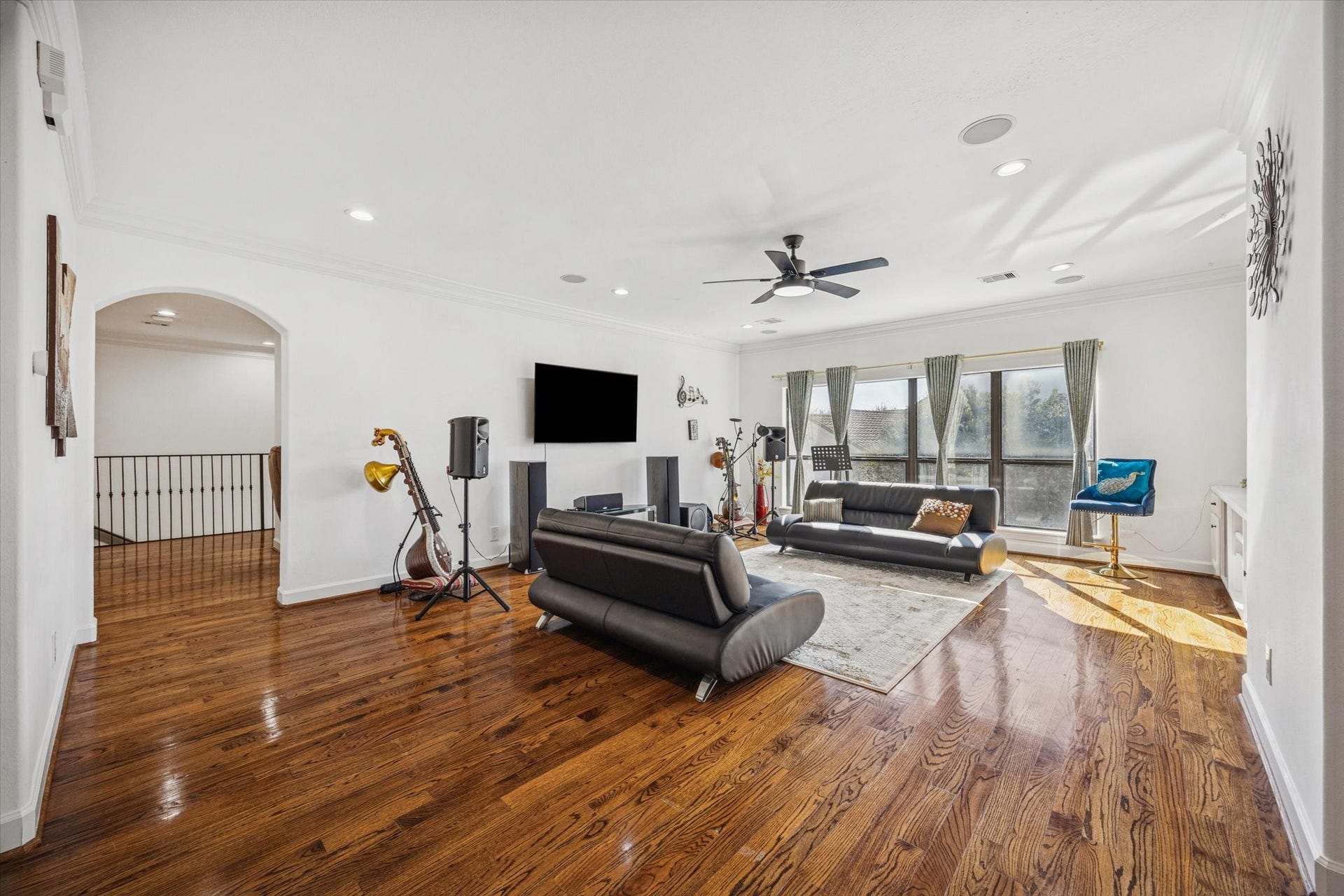 61 Open Sands Court, Sugar Land, TX 77479 Spacious, modern upstairs game room with hardwood floors, large windows, and ample natural light. Features recessed lighting, ceiling fan, and built in speakers. Ideal for entertaining.