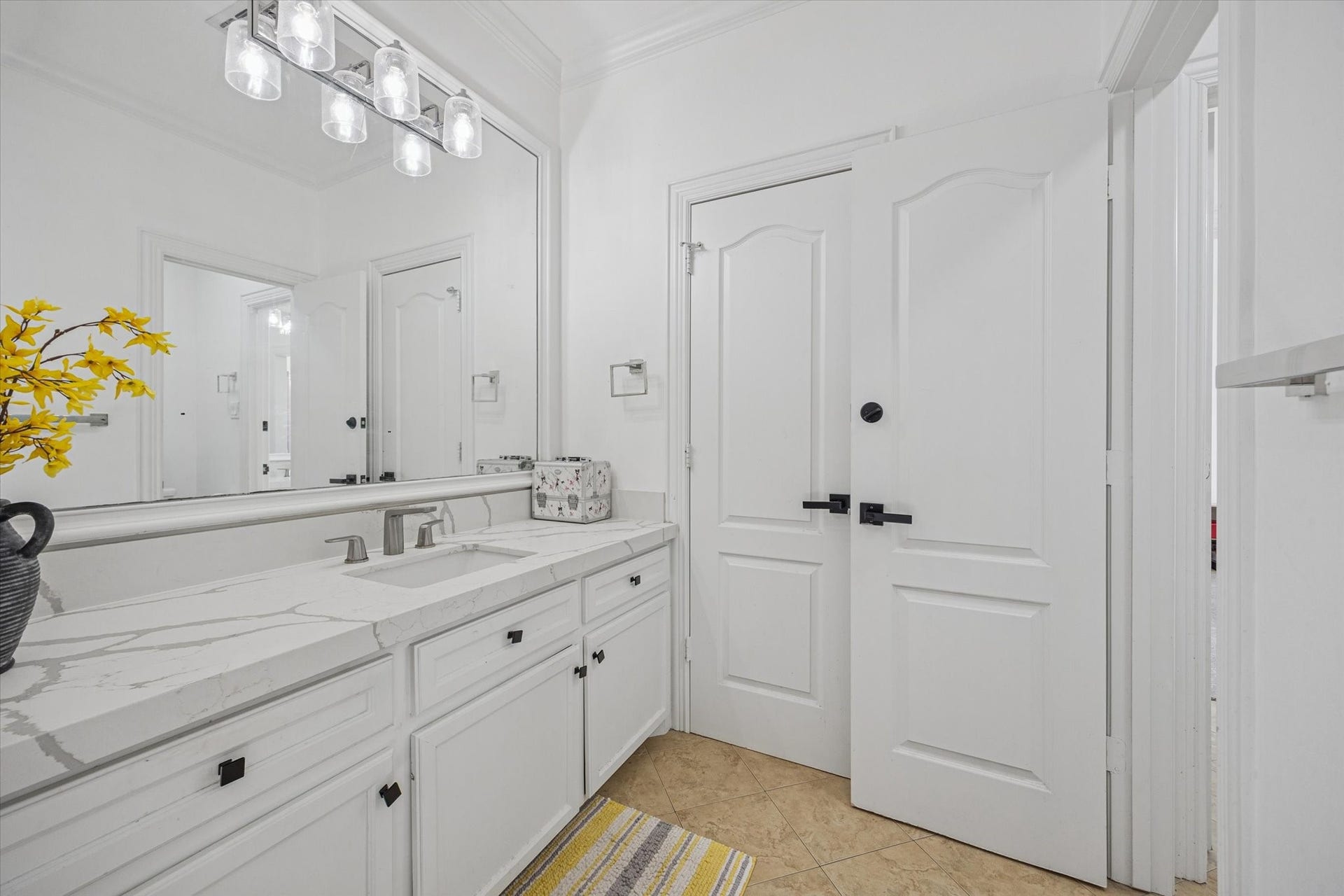 61 Open Sands Court, Sugar Land, TX 77479 One of 2 upstairs adjoining jack and jill bathrooms. Bright and clean bathroom featuring a large mirror, sleek modern fixtures, and a spacious vanity with a quartz countertop.