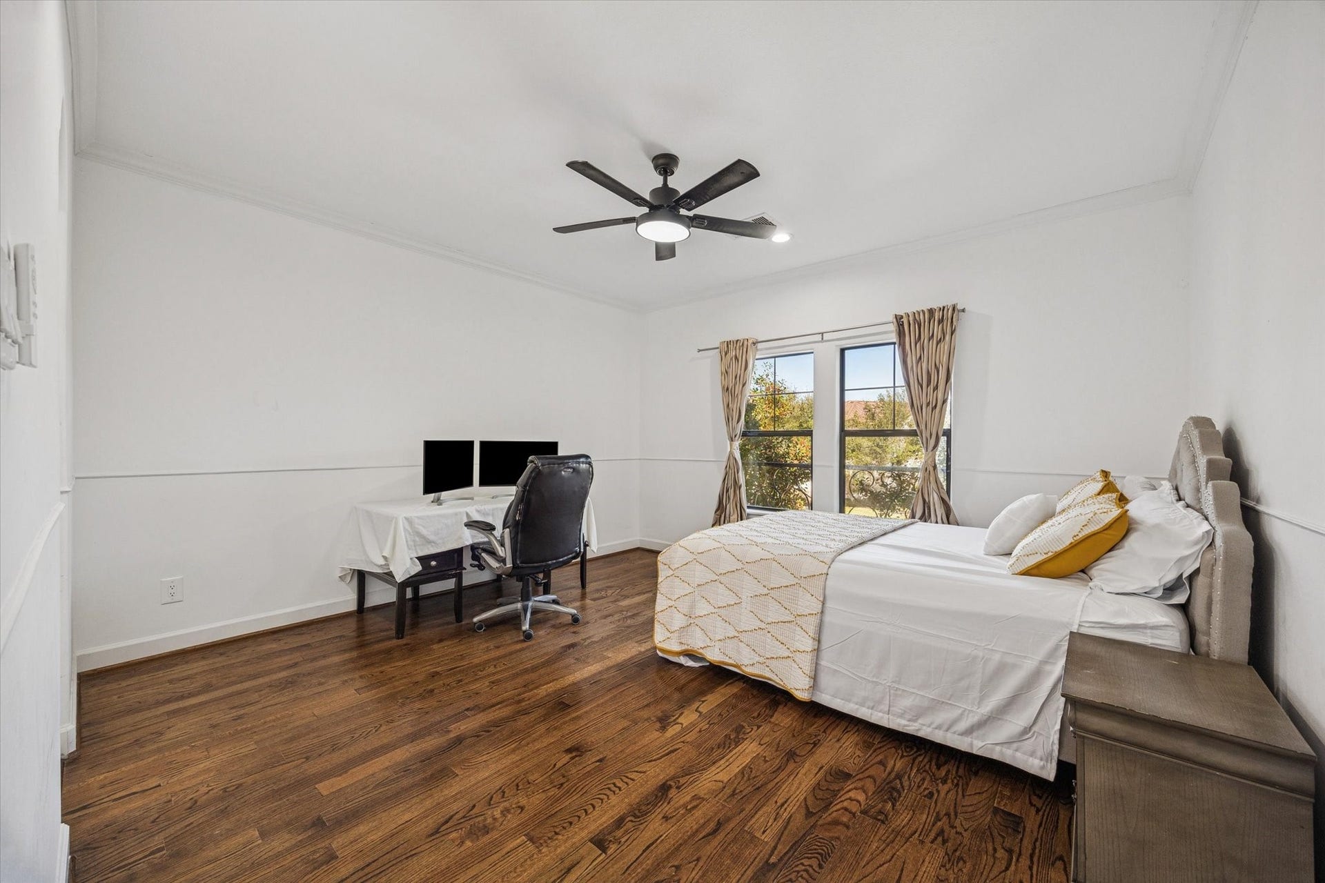 61 Open Sands Court, Sugar Land, TX 77479 This spacious bedroom features hardwood floors, a large window with natural light, and a modern ceiling fan.