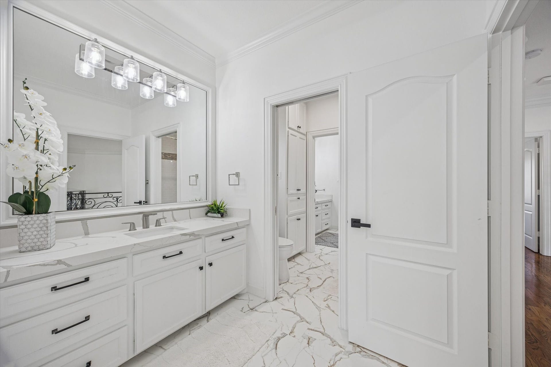 61 Open Sands Court, Sugar Land, TX 77479 One of 2 upstairs adjoining jack and jill bathrooms. Bright and clean bathroom featuring a large mirror, sleek modern fixtures, and a spacious vanity with a quartz countertop.