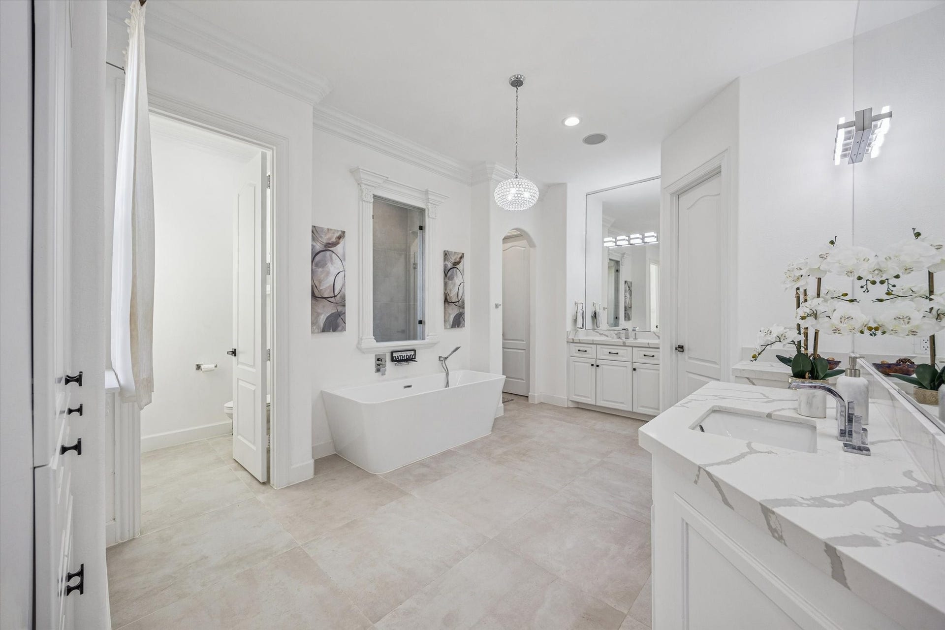 61 Open Sands Court, Sugar Land, TX 77479 This spacious bathroom features a modern freestanding tub, stylish dual vanities with marble countertops, and elegant lighting. The neutral tones and ample natural light create a relaxing, spa-like atmosphere.