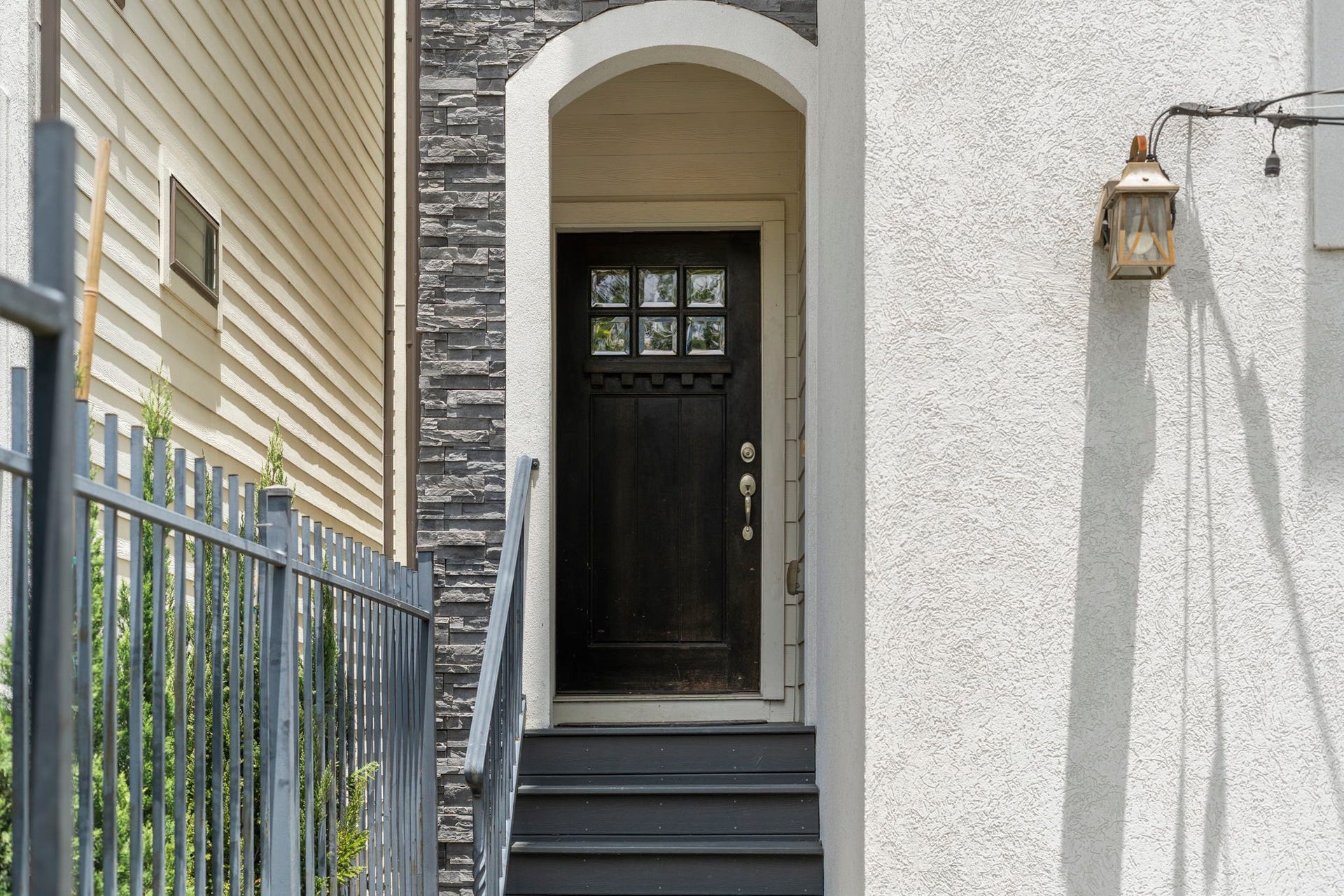 1629 W 23rd Street, Houston, TX 77008 Modern stone and stucco exterior featuring a covered front entry and an inviting Craftsman-style front door that creates a warm and welcoming first impression.