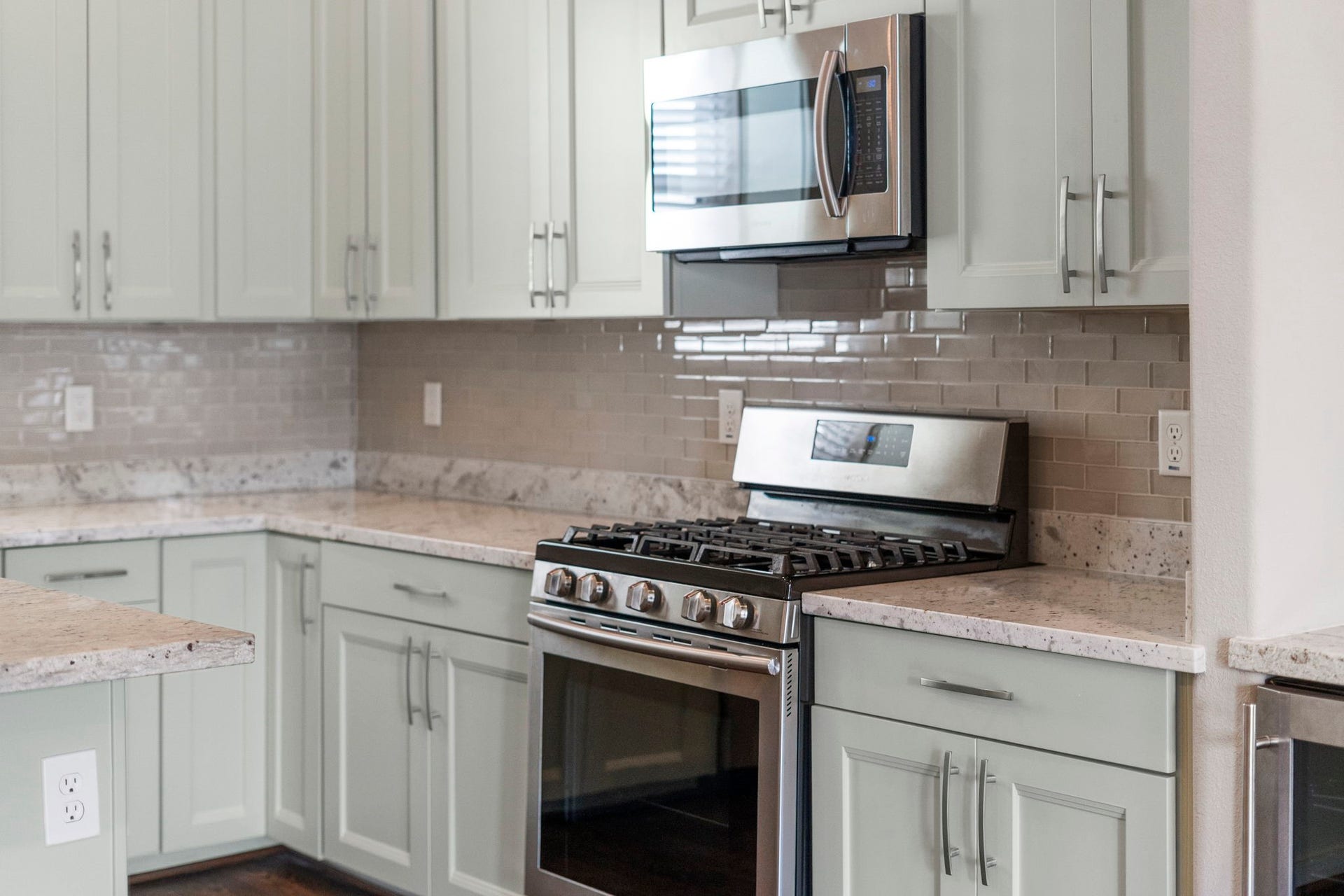 1629 W 23rd Street, Houston, TX 77008 Timeless light granite countertops paired with a glass subway tile backsplash create a bright and elegant kitchen design.
