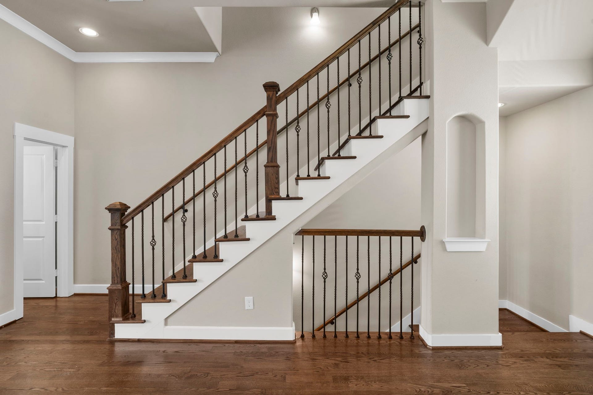 1629 W 23rd Street, Houston, TX 77008 Classic solid oak stairs, complemented by a custom railing and wrought-iron spindles, create an elegant architectural focal point in the home.