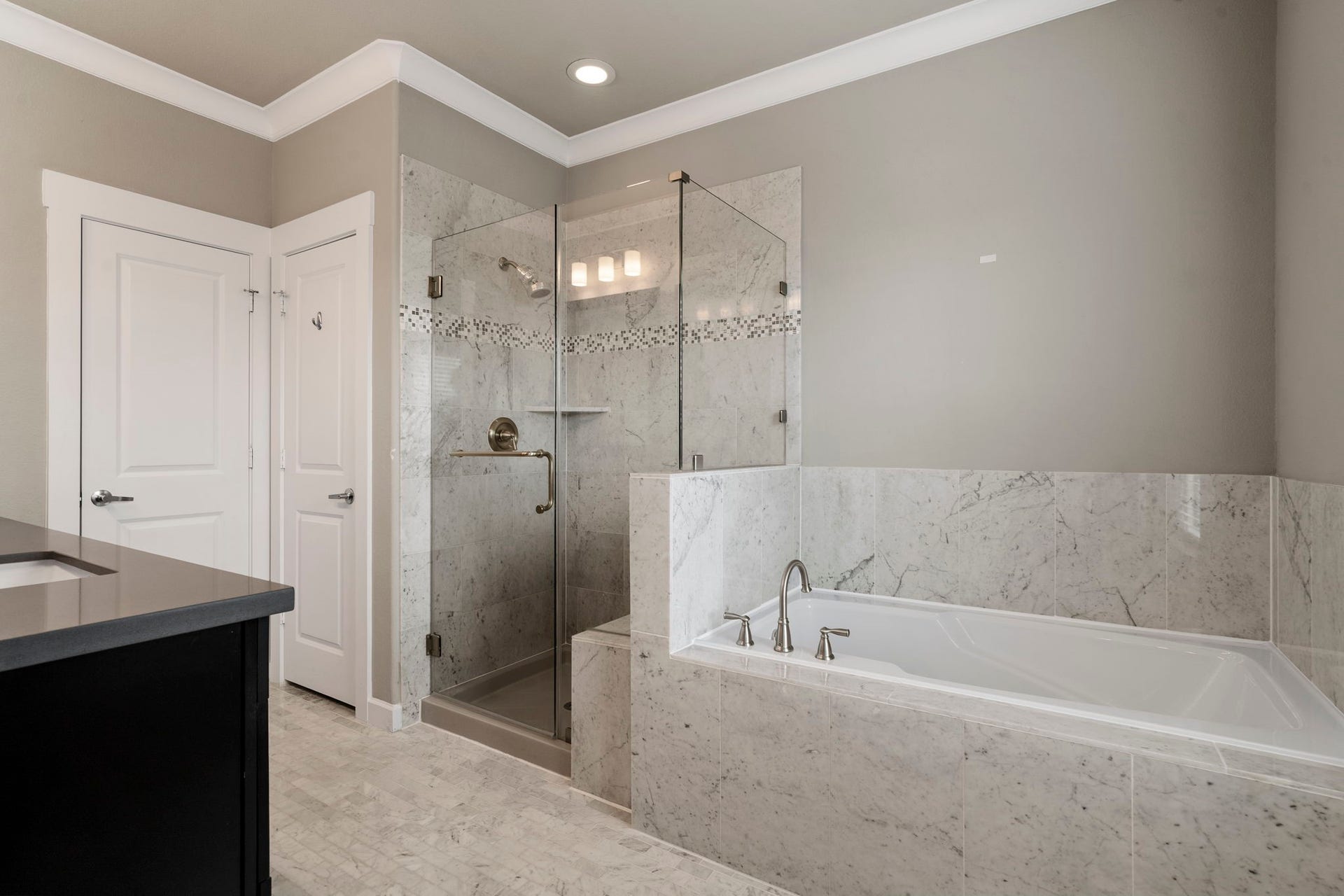 1629 W 23rd Street, Houston, TX 77008 The spa-inspired primary en suite bath features dual vanities, a soaking tub, a walk-in shower, linen closet, and a large walk-in closet.
