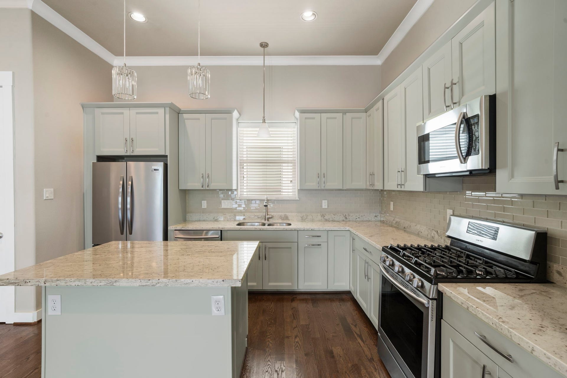 1629 W 23rd Street, Houston, TX 77008 The stunning island kitchen boasts a gas range, pantry, breakfast bar, beverage refrigerator, abundant cabinetry, and generous counter space.