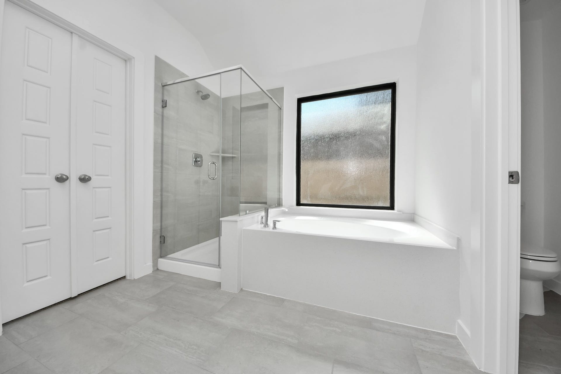 3068 Spoolwood Trail, Magnolia, TX 77355 Indulge in a spa-like retreat within the confines of this primary bathroom. Delight in a spacious walk-in shower enveloped in stylish tile surround, unwind in a separate garden tub adorned with custom detailing.