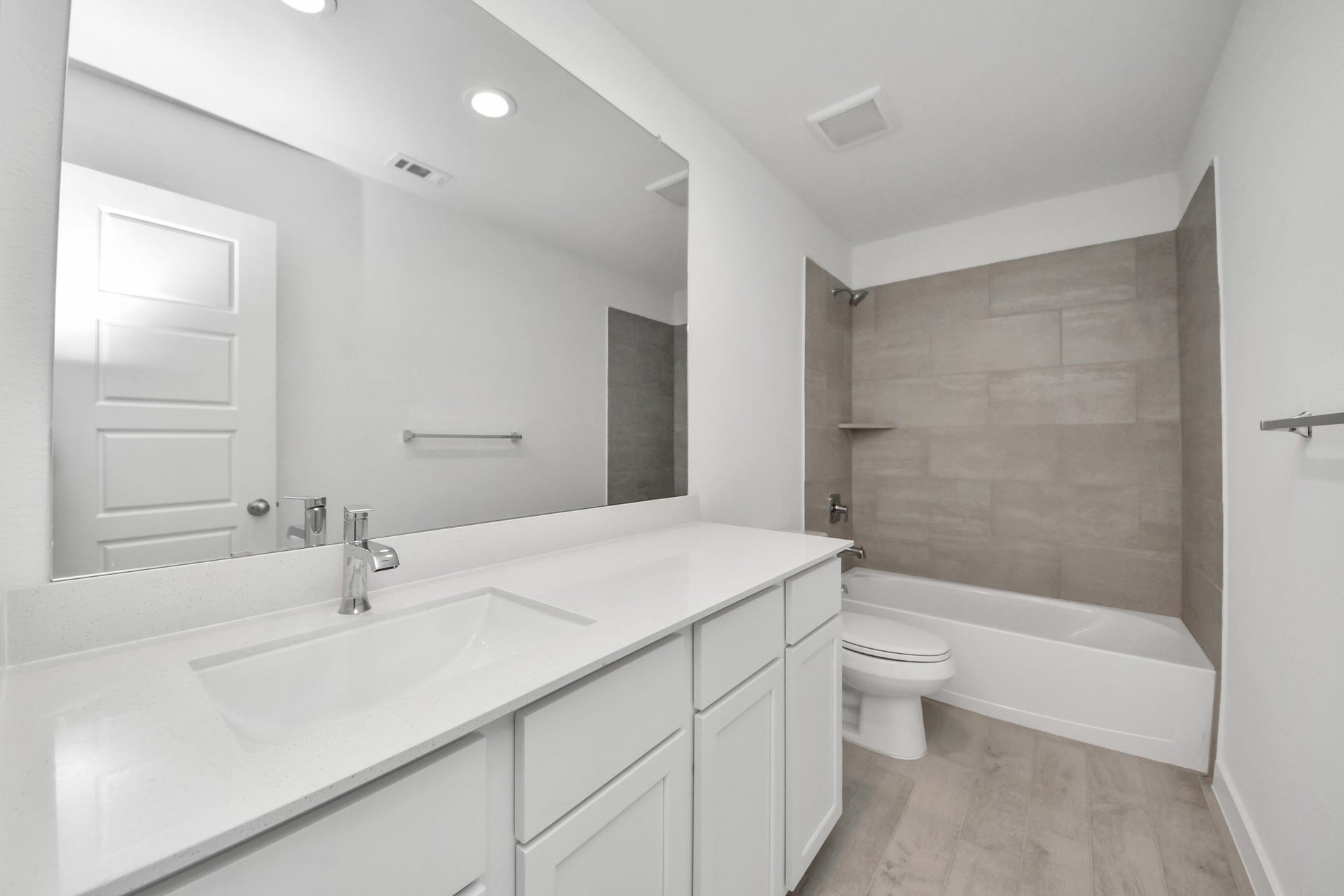 3068 Spoolwood Trail, Magnolia, TX 77355 Secondary bath features tile flooring, bath/shower combo with tile surround, light stained wood cabinets, beautiful light countertop.