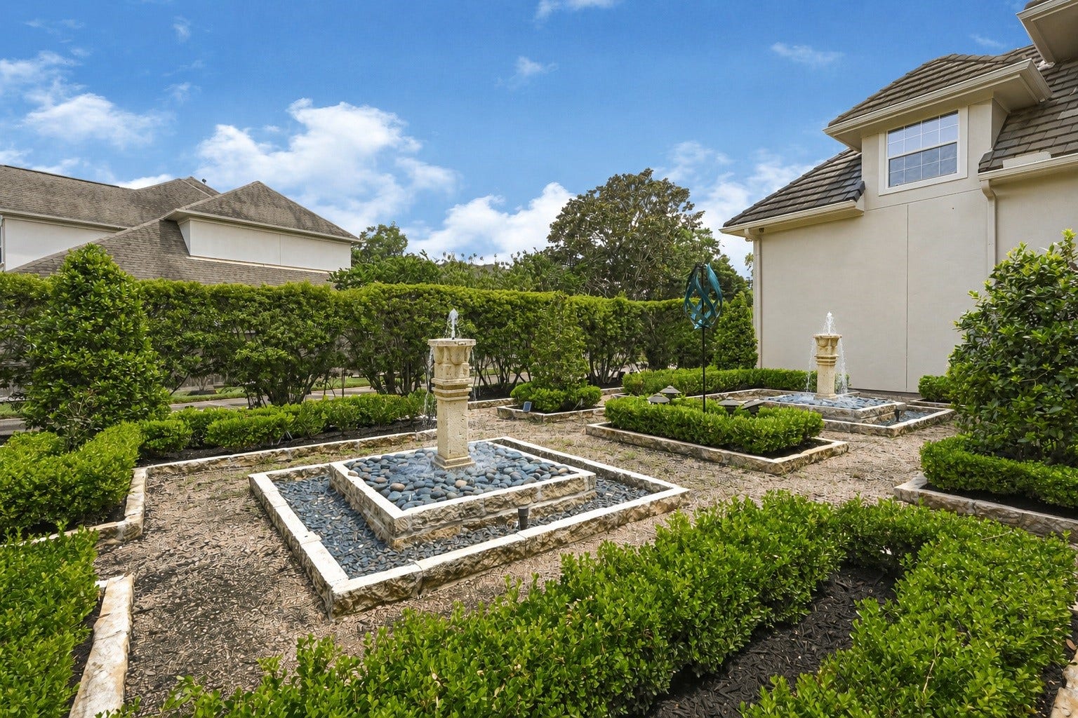 3 Waterford Pointe Circle, Sugar Land, TX 77479 Elegant backyard features beautifully landscaped gardens with stone-bordered pathways and tranquil fountains, offering a serene outdoor retreat.