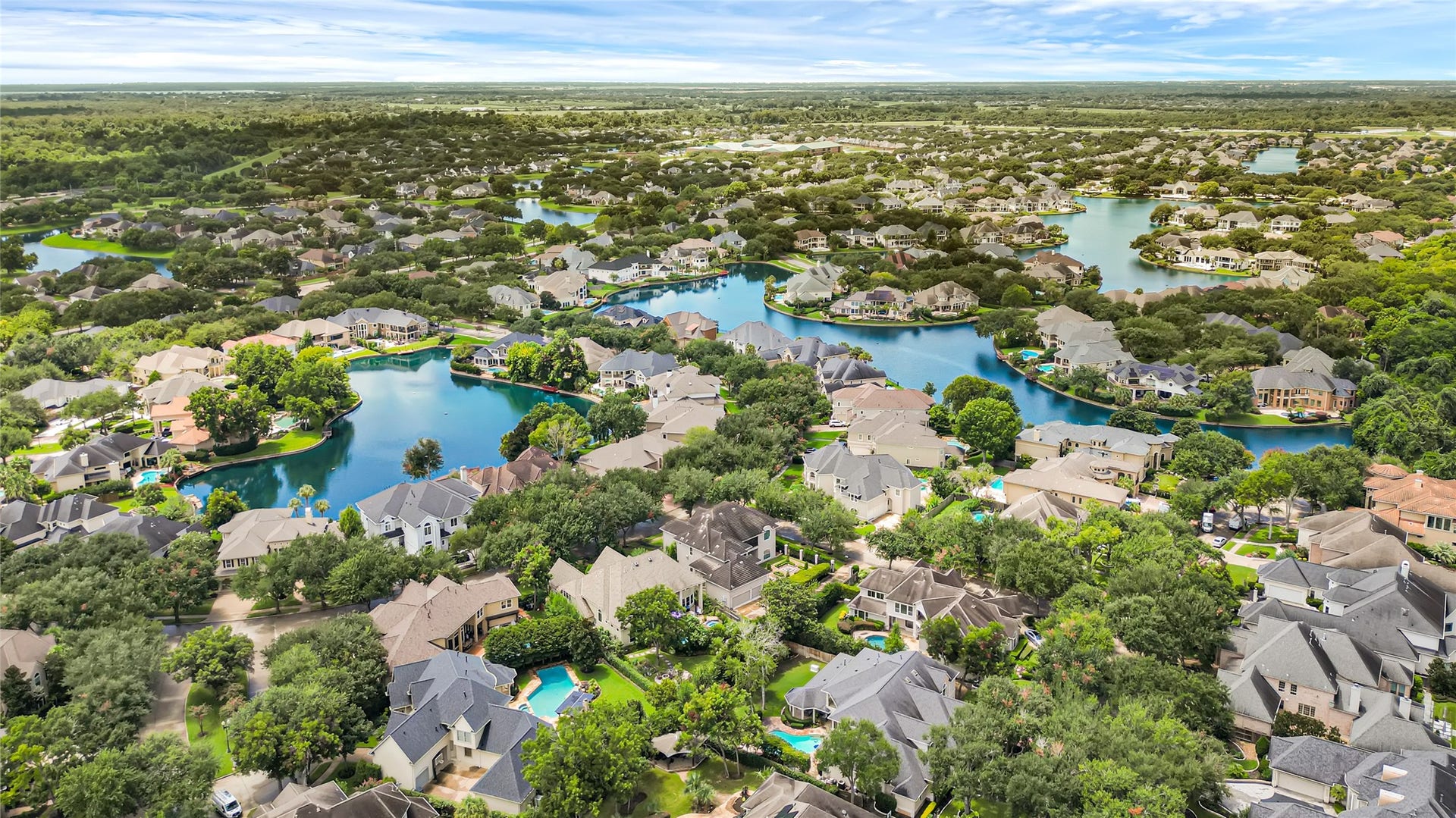 3 Waterford Pointe Circle, Sugar Land, TX 77479 Nestled in a picturesque community, this aerial view showcases serene lakes surrounded by lush greenery and elegant homes, offering a tranquil and scenic living environment.