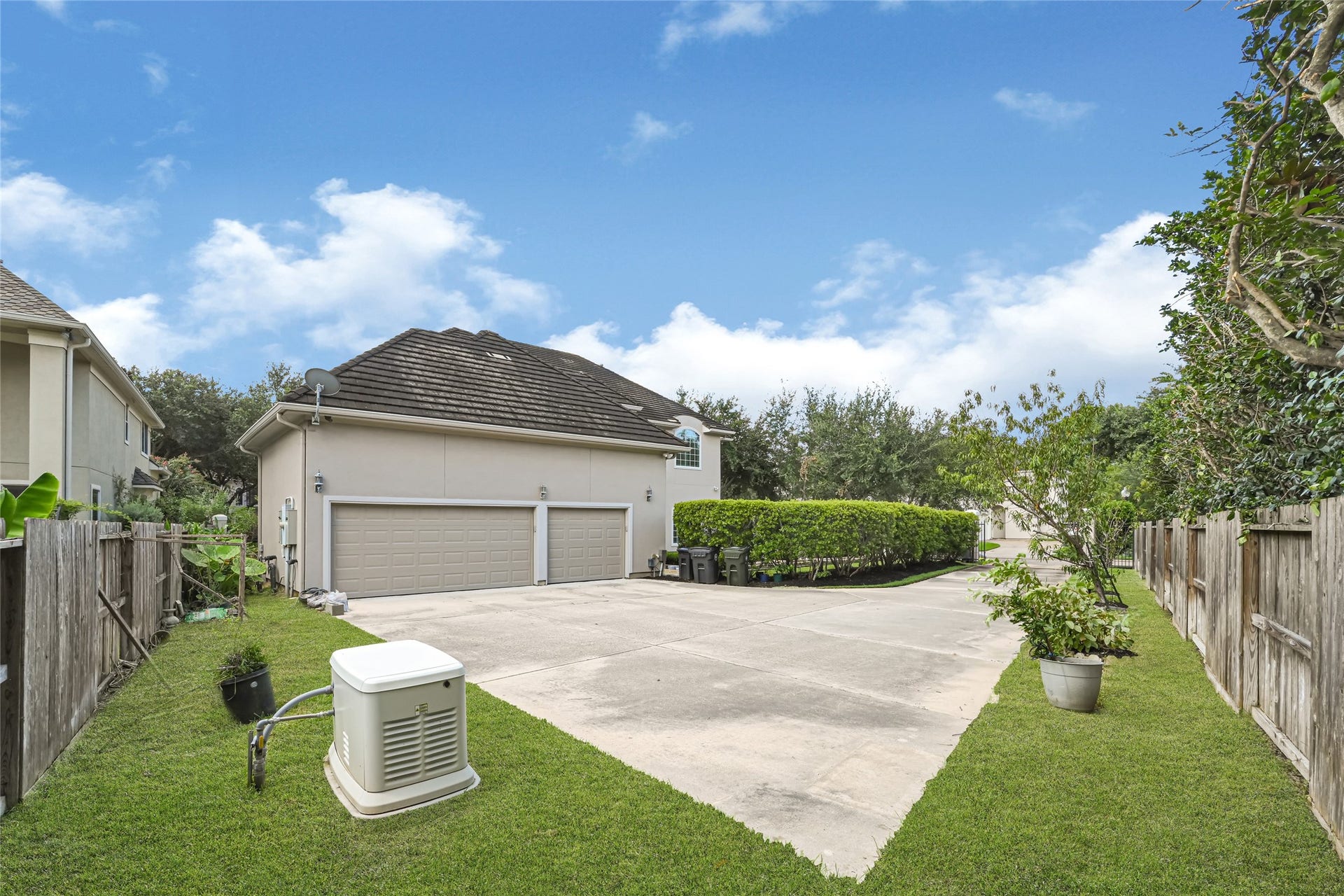 3 Waterford Pointe Circle, Sugar Land, TX 77479 Expansive driveway leading to a spacious three-car garage, surrounded by neatly manicured lawns and lush greenery for privacy and curb appeal.
