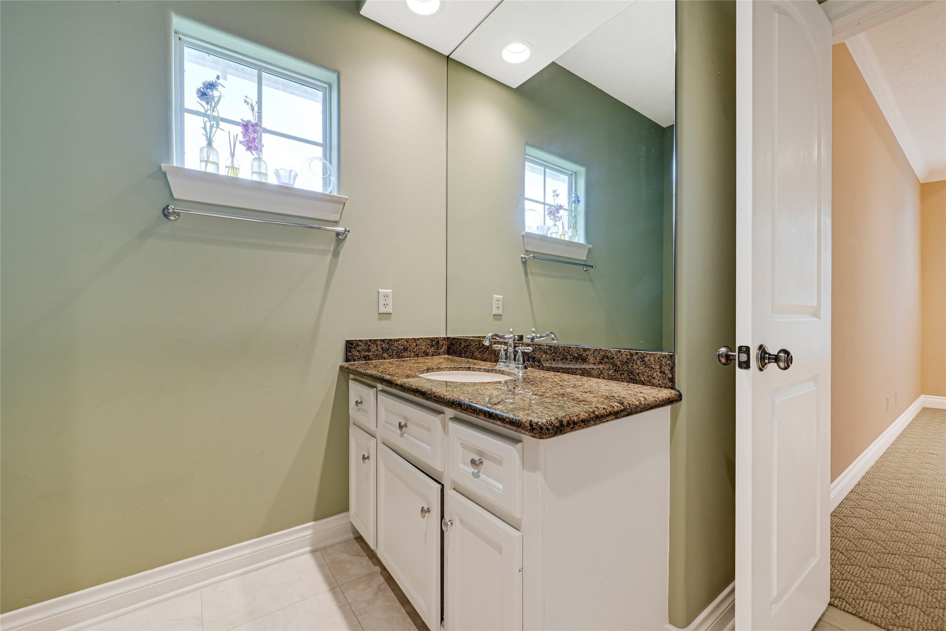 3 Waterford Pointe Circle, Sugar Land, TX 77479 Bathroom featuring a sleek granite countertop, elegant white cabinetry, and a large mirror that enhances the space. Natural light streams through the small window, adding warmth and brightness.