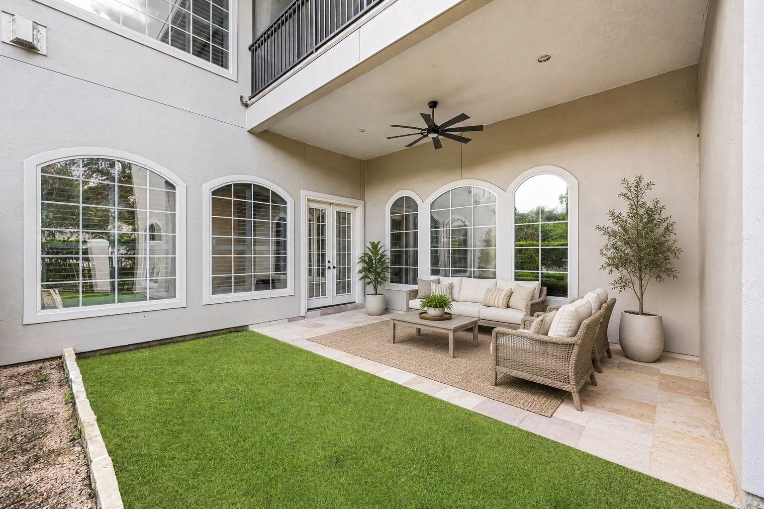 3 Waterford Pointe Circle, Sugar Land, TX 77479 Elegant courtyard with lush greenery, stylish seating, and large windows offering abundant natural light.