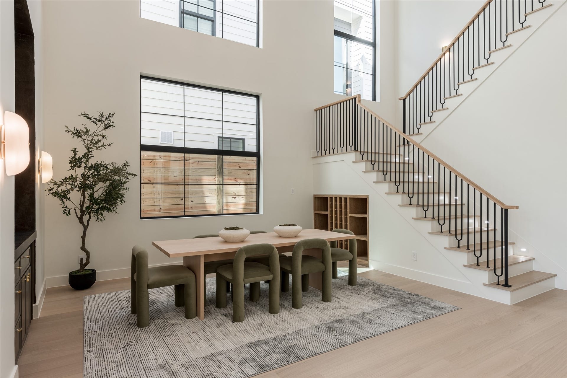 1109 Voight Street, Houston, TX 77009 The dramatic two story dining room is framed by soaring windows that draw natural light through the space, while a dedicated dry bar and built in wine/display cove turn entertaining into part of the architecture.