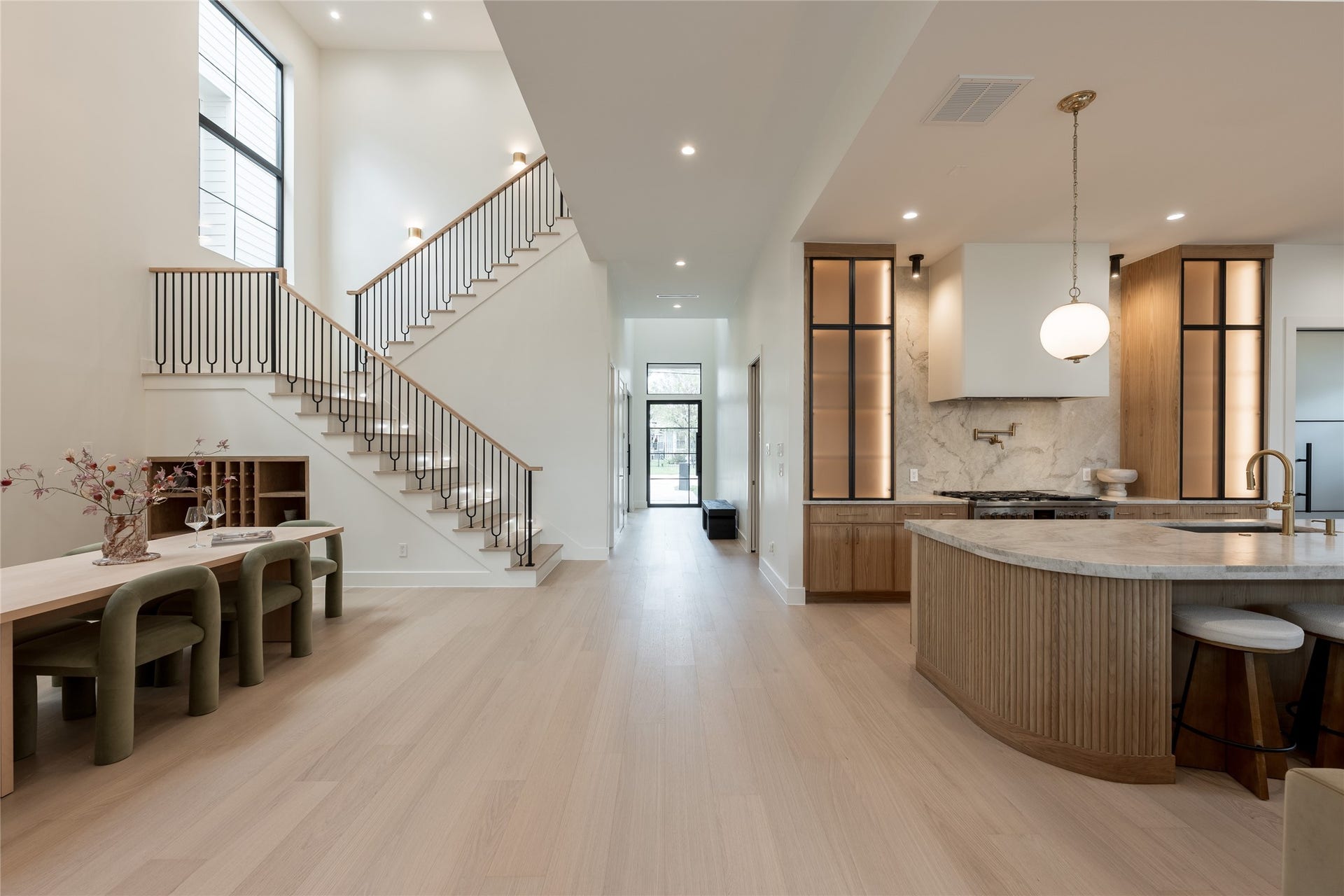1109 Voight Street, Houston, TX 77009 A long interior sightline reveals the homes scale and flow, with the two story dining room, custom white oak staircase and chefs kitchen unfolding seamlessly toward the great room beyond.