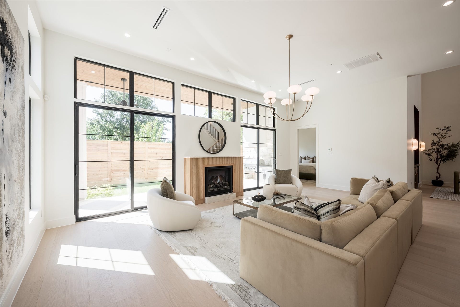 1109 Voight Street, Houston, TX 77009 The great room balances dramatic scale with warmth, pairing 12 foot ceilings and a fluted fireplace with walls of grid windows that bring natural light deep into the space.