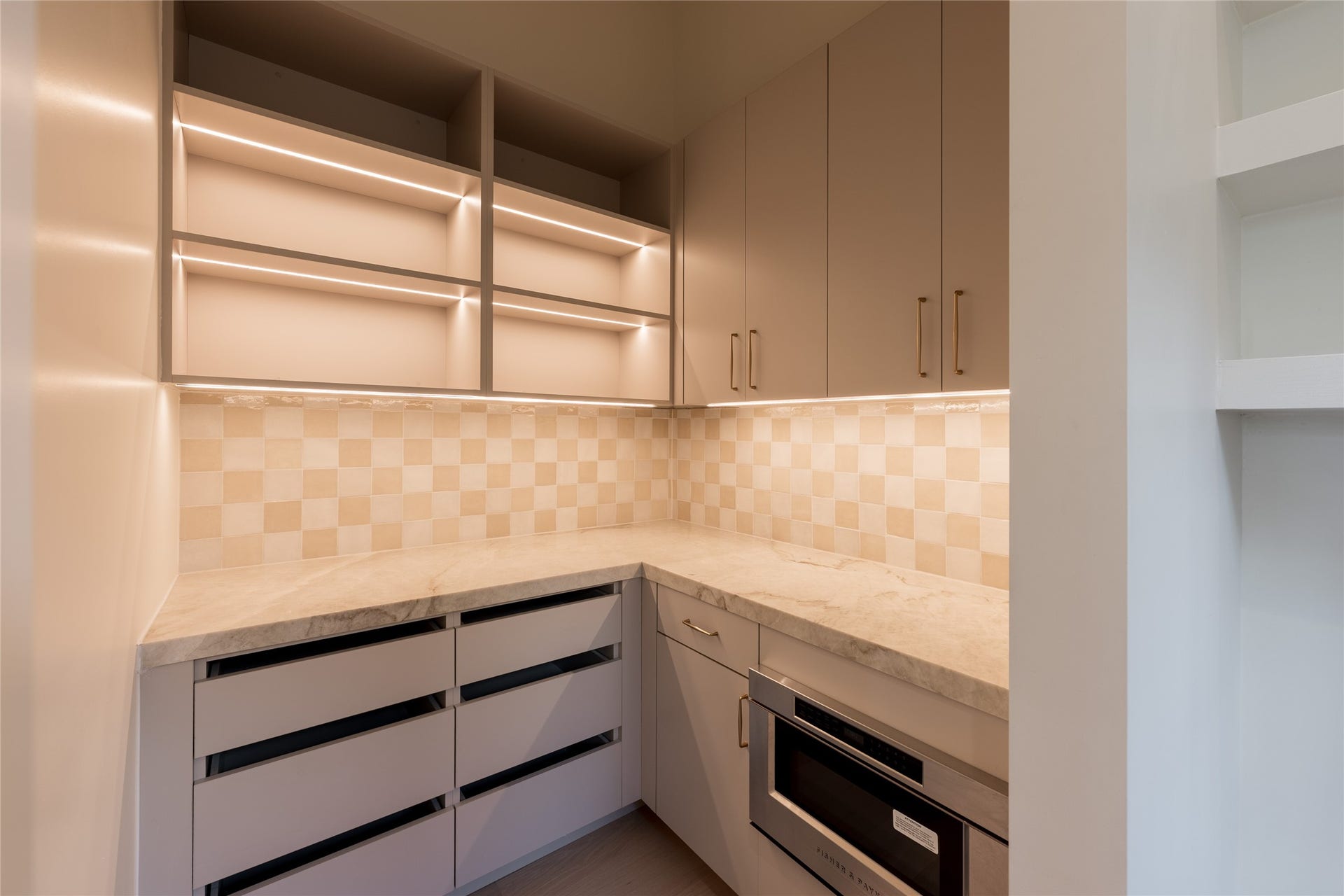 1109 Voight Street, Houston, TX 77009 Integrated lighting turns the butlers pantry into a design moment of its own, illuminating generous cabinetry, natural stone counters and dedicated prep space while keeping the working side of the kitchen discreetly tucked away.